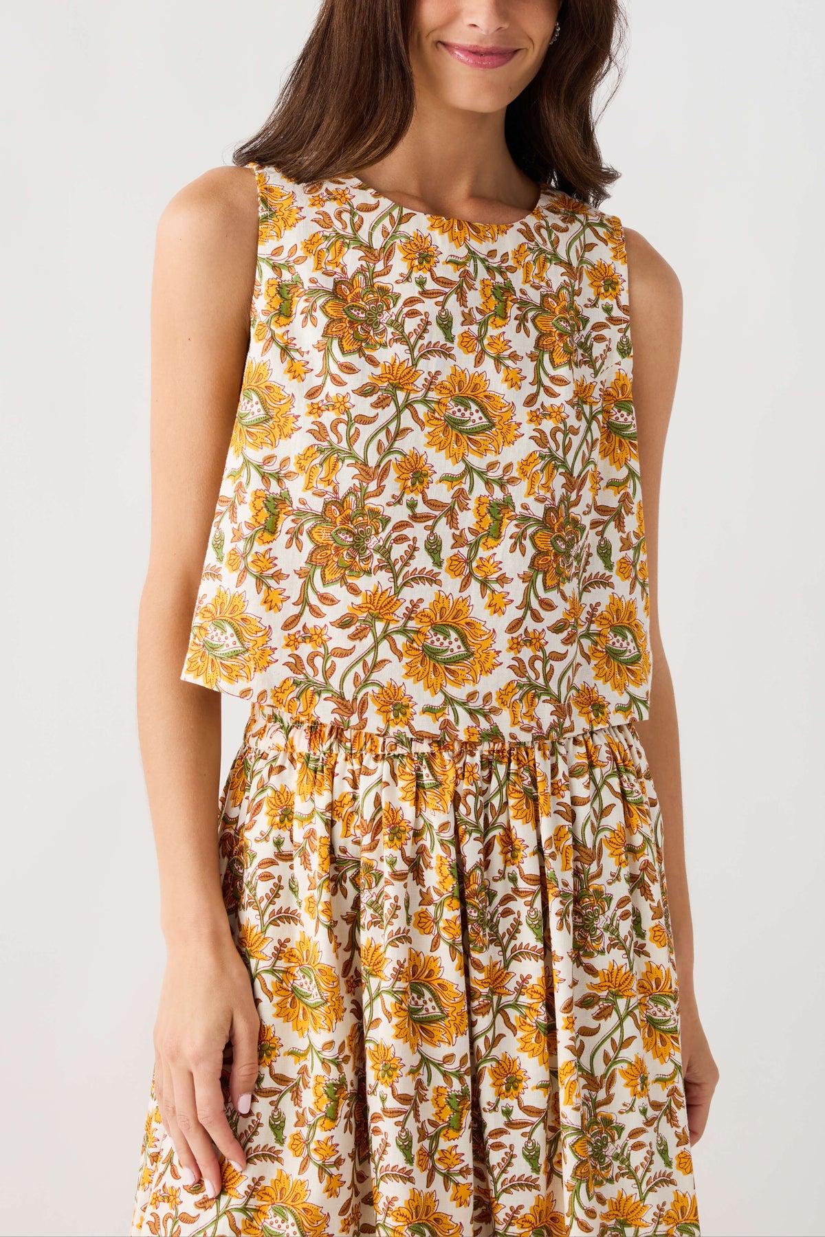 Floral print sleeveless top with round neckline, button front, and gathered peplum hem