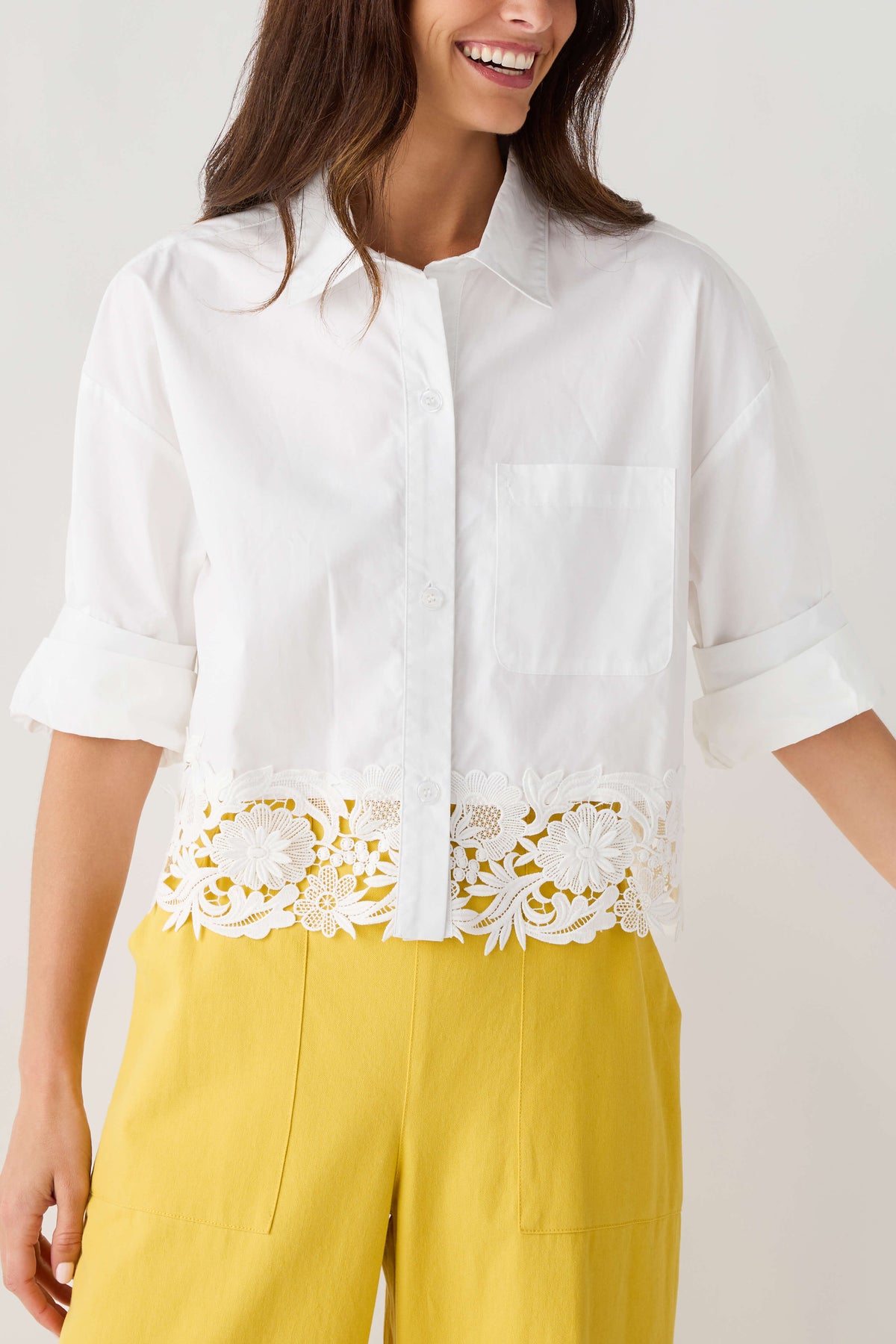 White poplin top with half-length sleeves, button placket, and lace panel hem