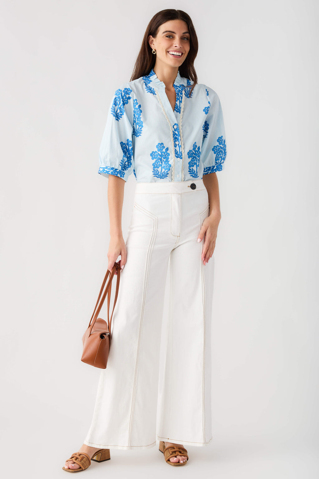 Cream high-waisted flare pants with belt loops, front pockets, and wide leg opening.