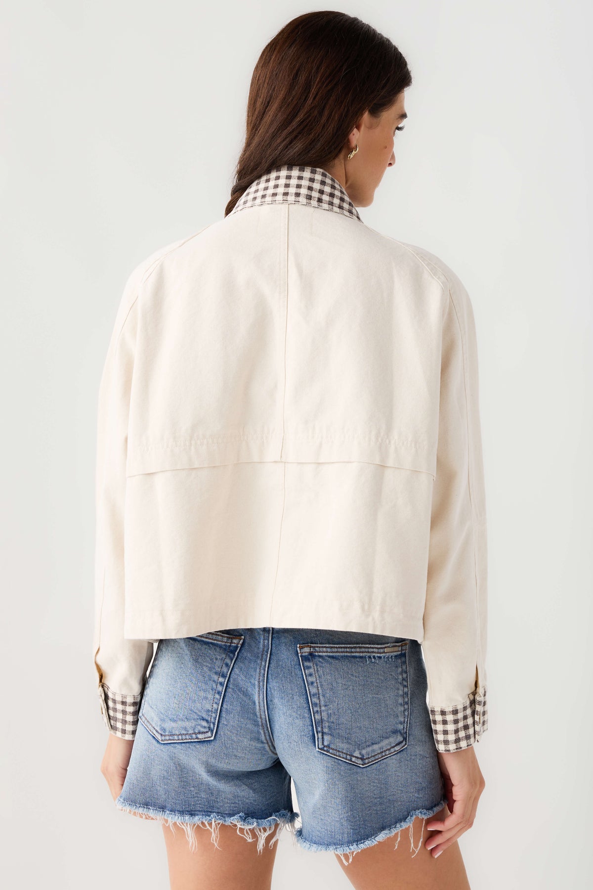Back view of beige twill jacket with center back seam and gingham inner cuffs