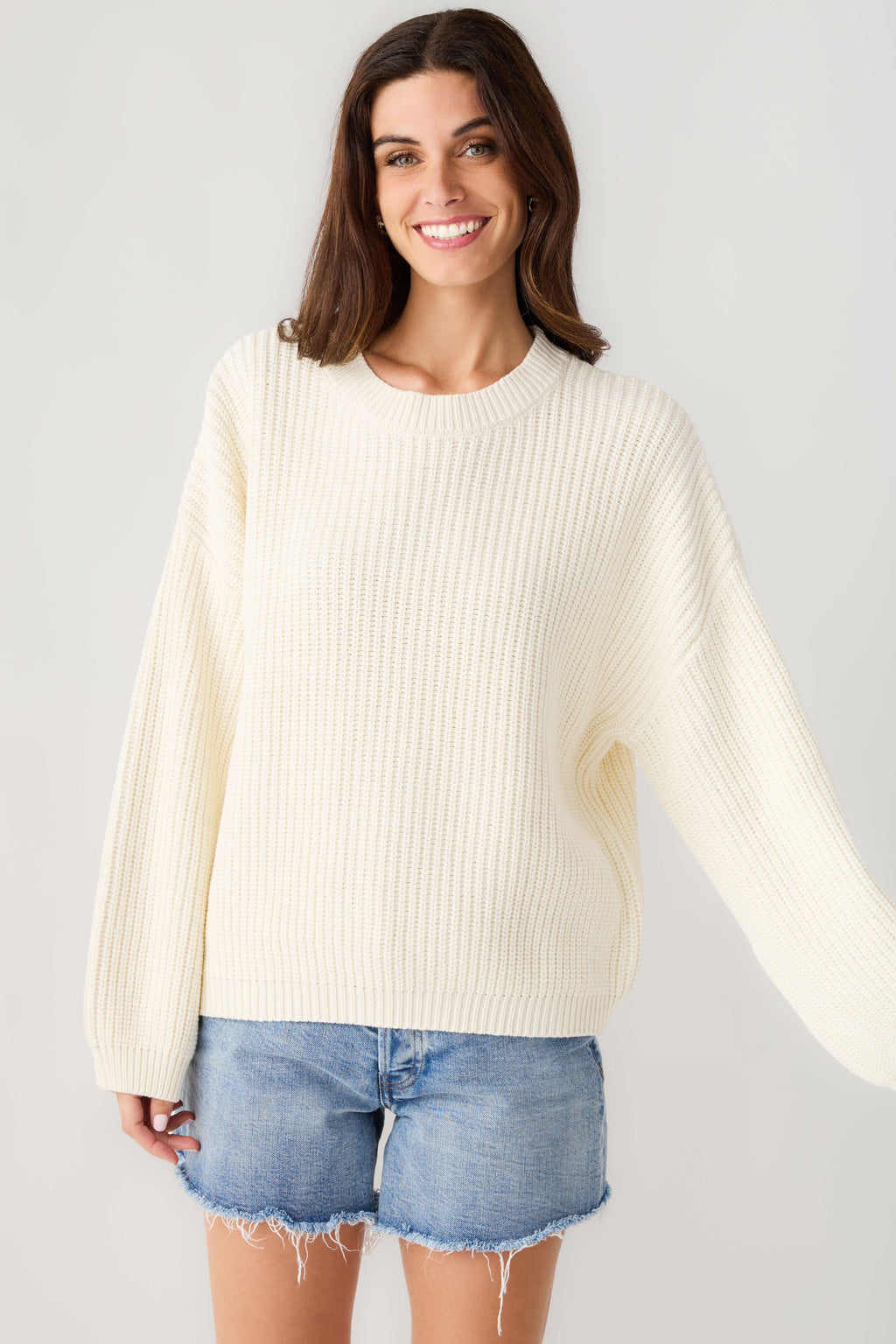 Cream knit pullover top with ribbed crew neck and long sleeves