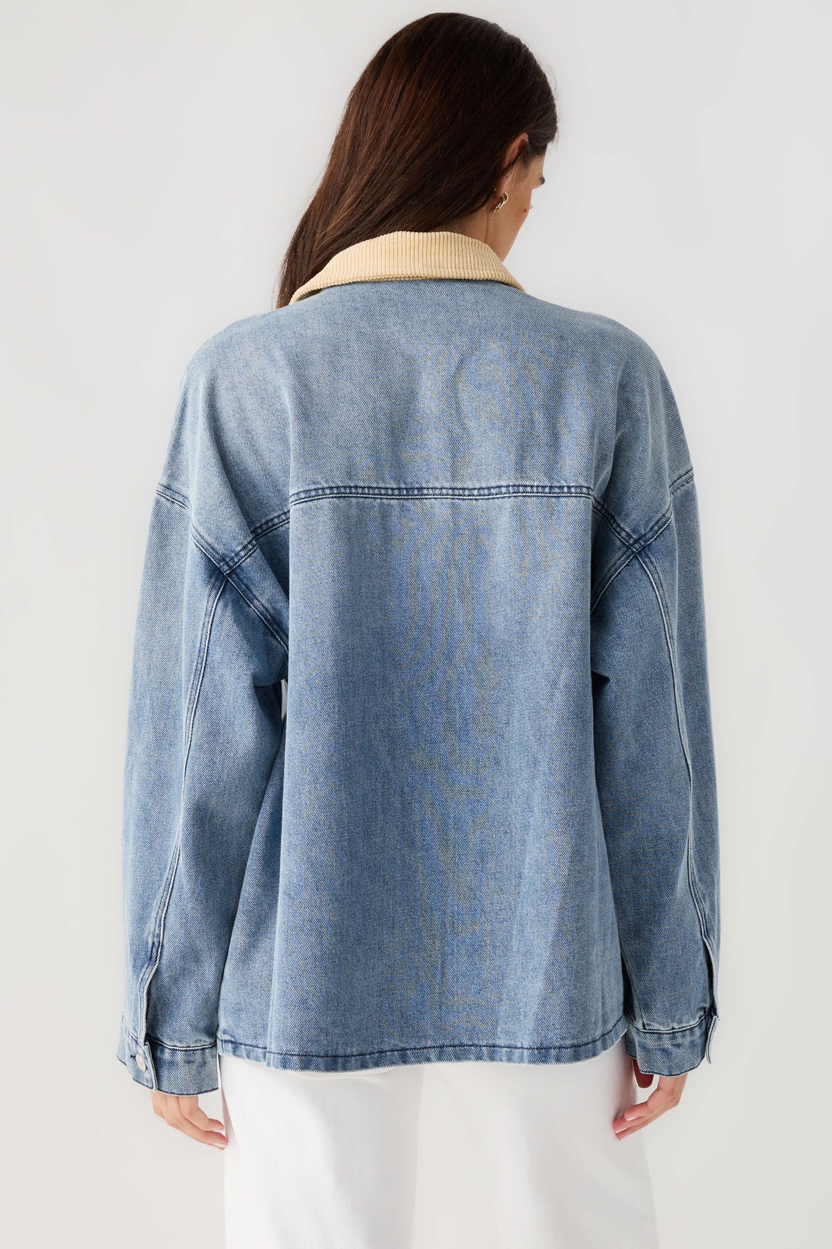 Light blue denim jacket back view with tan corduroy collar and yoke stitching