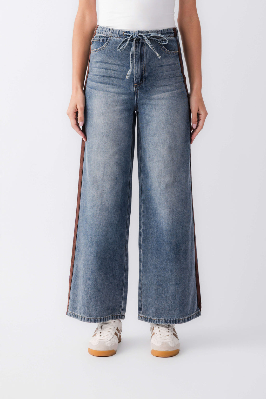 Wide-leg denim jeans with front pockets, drawstring waist, and outer-leg varsity stripes