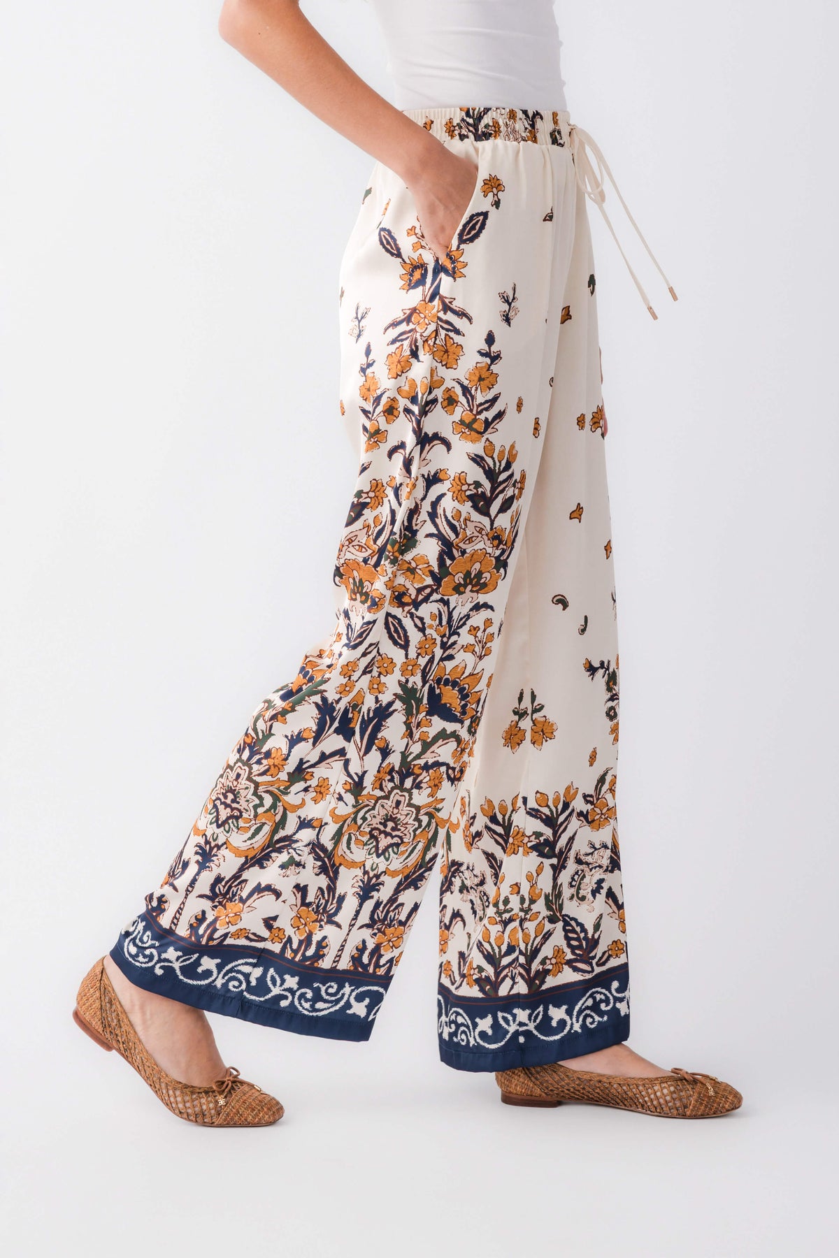 Ivory satin wide-leg pants with navy floral print and drawstring waist ties
