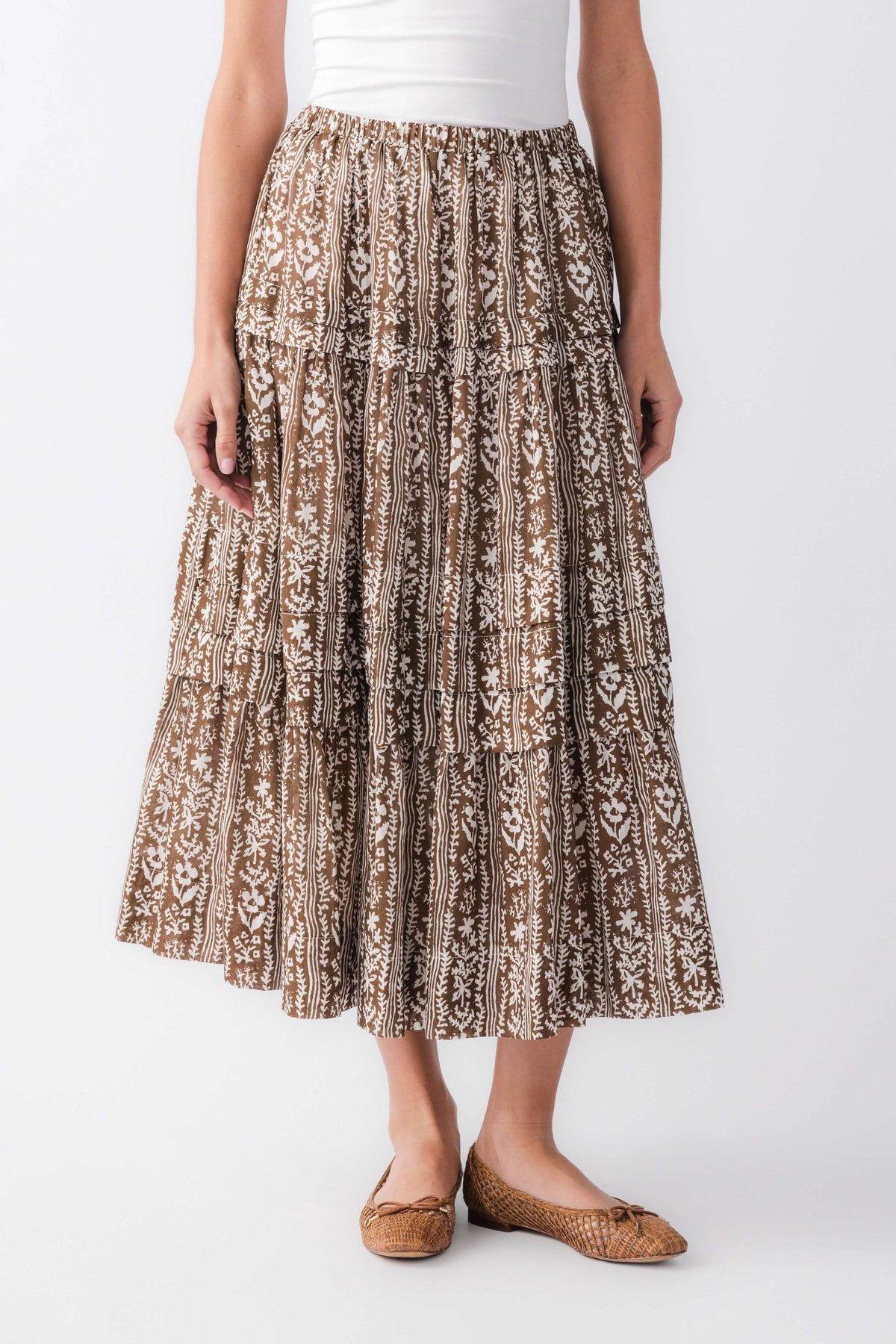 Front view of mocha printed tiered maxi skirt with elastic waist and ornate brown/black motif