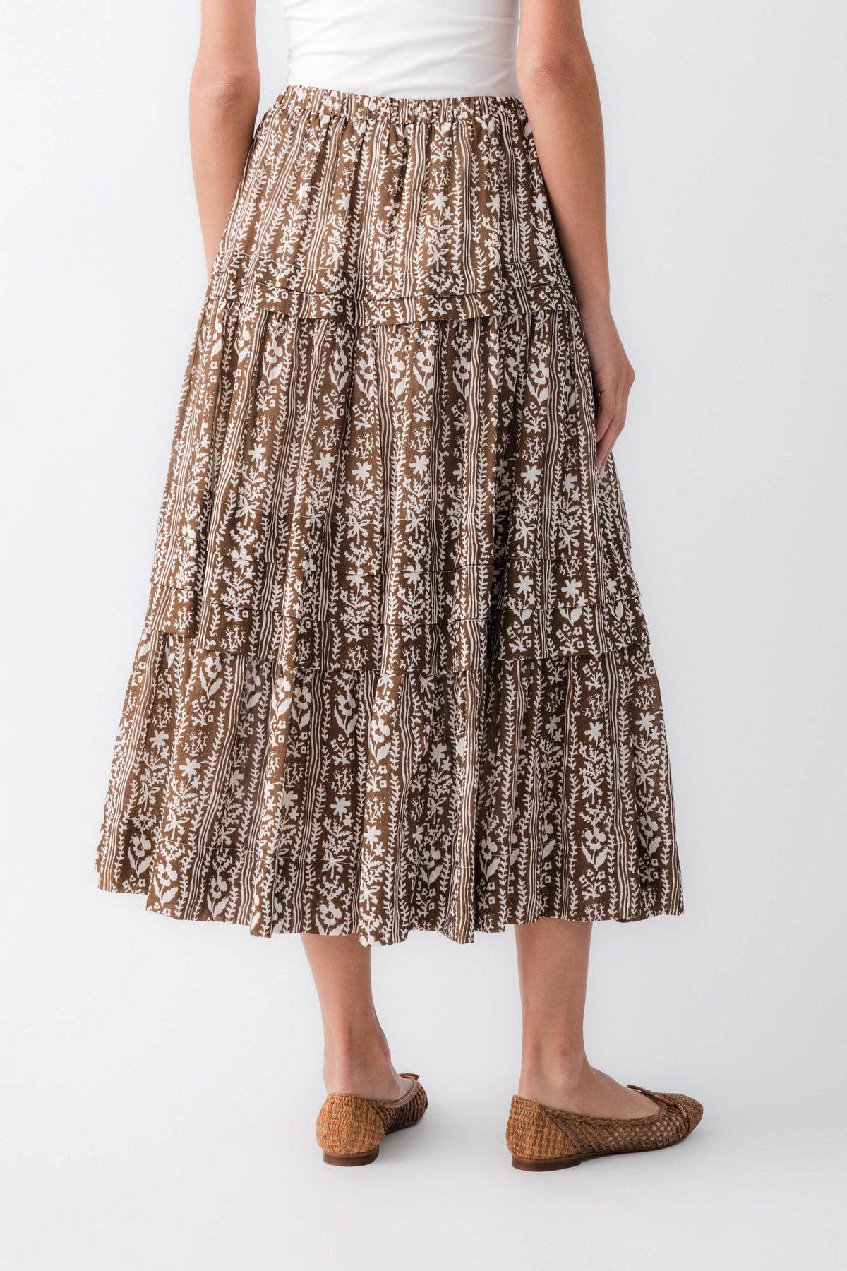 Rear view of mocha printed tiered maxi skirt showing gathered pleats and brown/black print