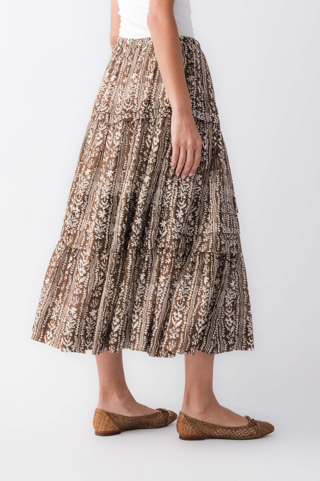 Three-quarter view of mocha printed tiered maxi skirt with flowing tiers and brown/black pattern