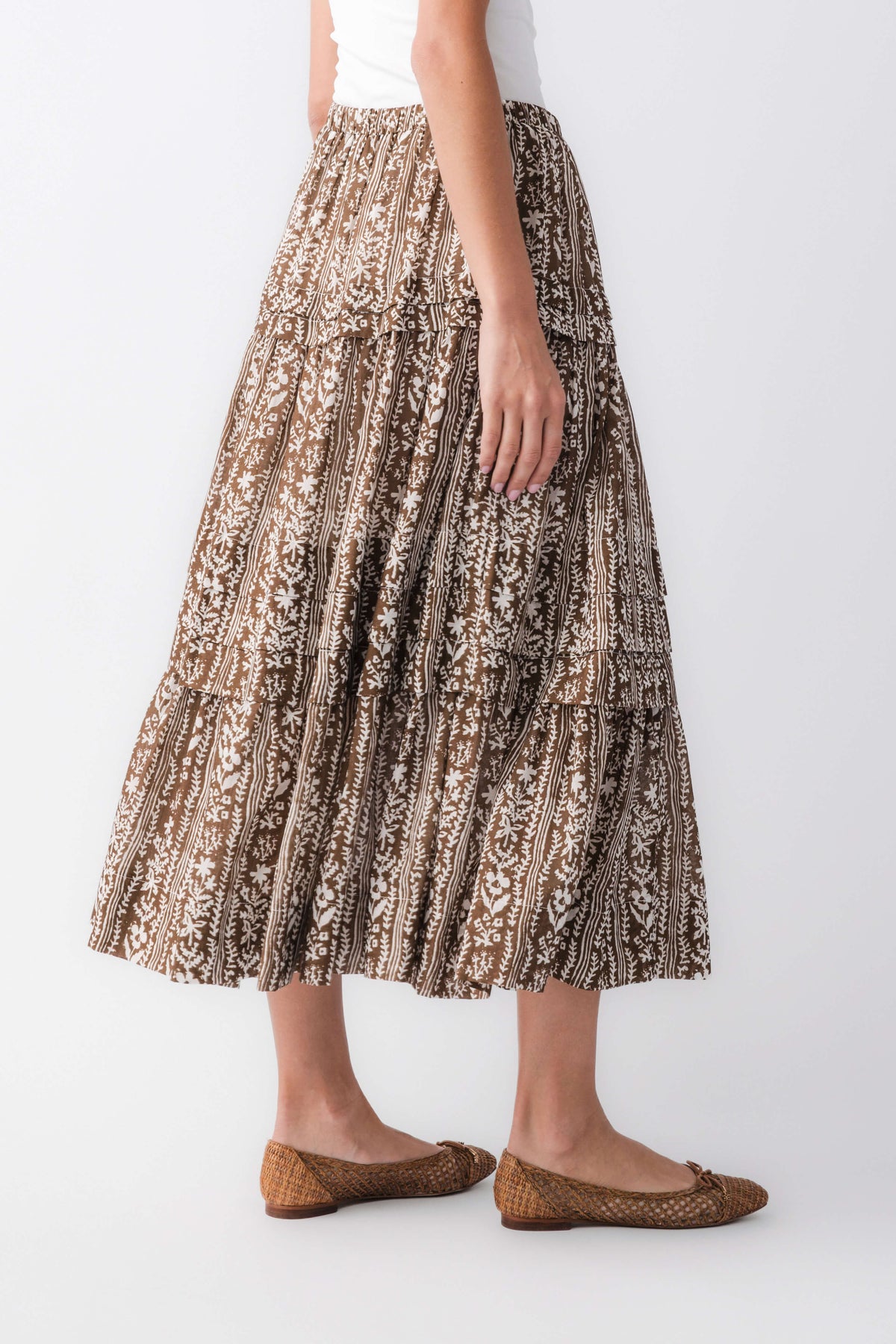 Three-quarter view of mocha printed tiered maxi skirt with flowing tiers and brown/black pattern
