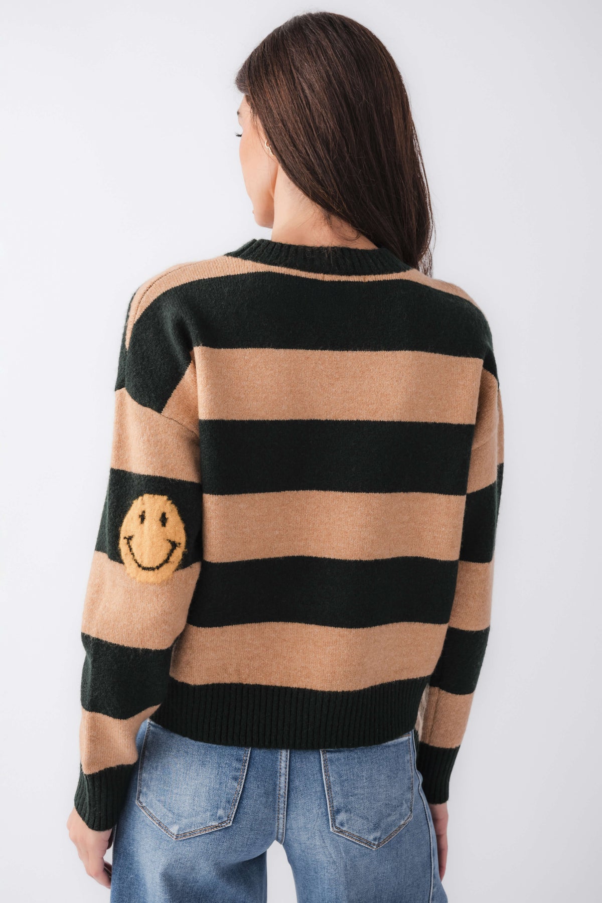 By Together striped sweater back view with smiley face patch, black and camel stripes.