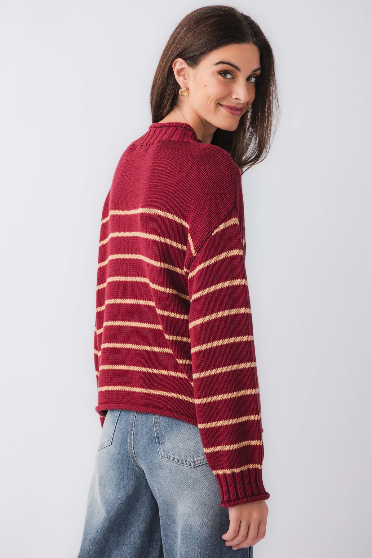 Burgundy striped knit mockneck sweater, angled back view with ribbed cuffs