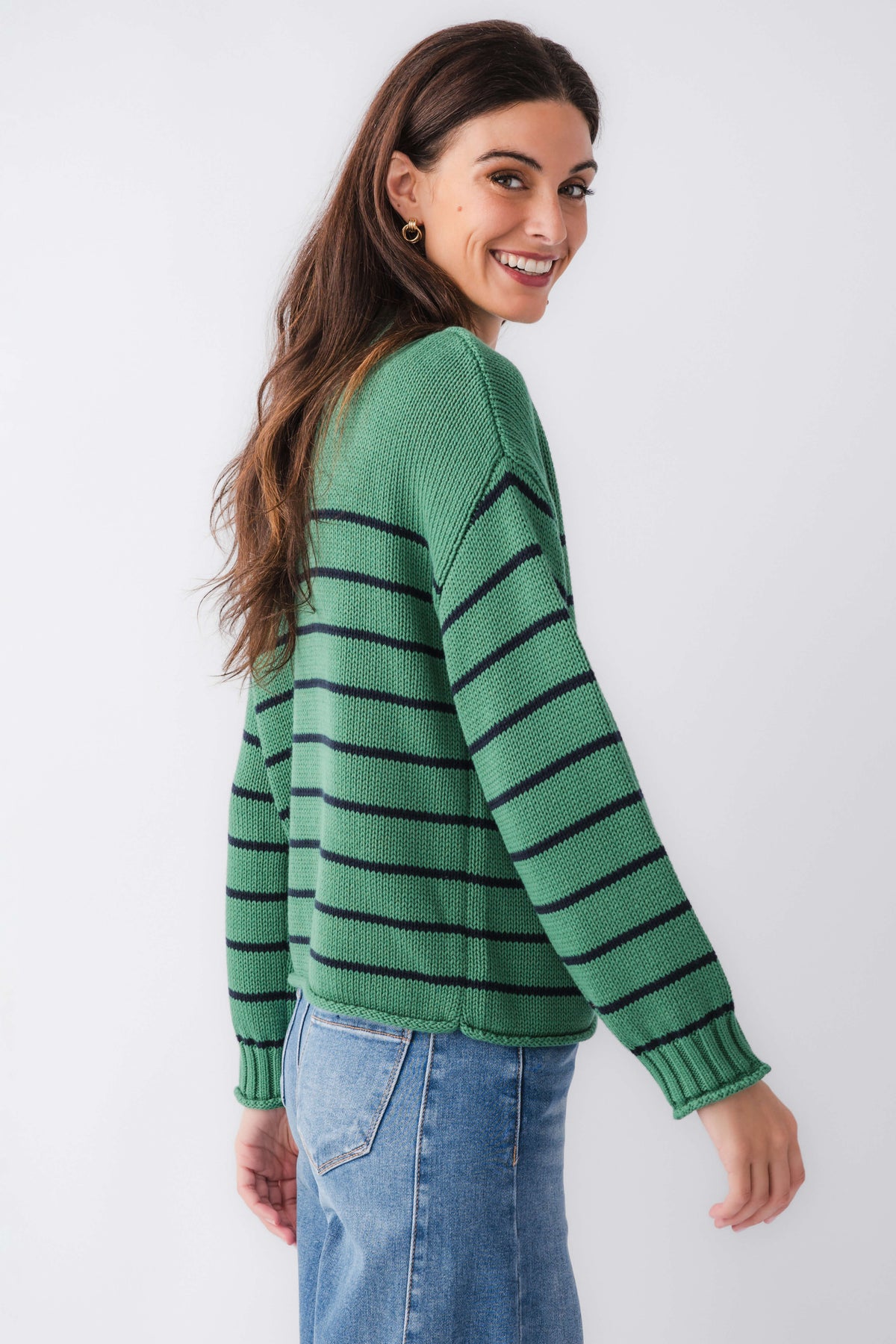 Green knit mockneck sweater, side view with navy horizontal stripes and ribbed cuffs.