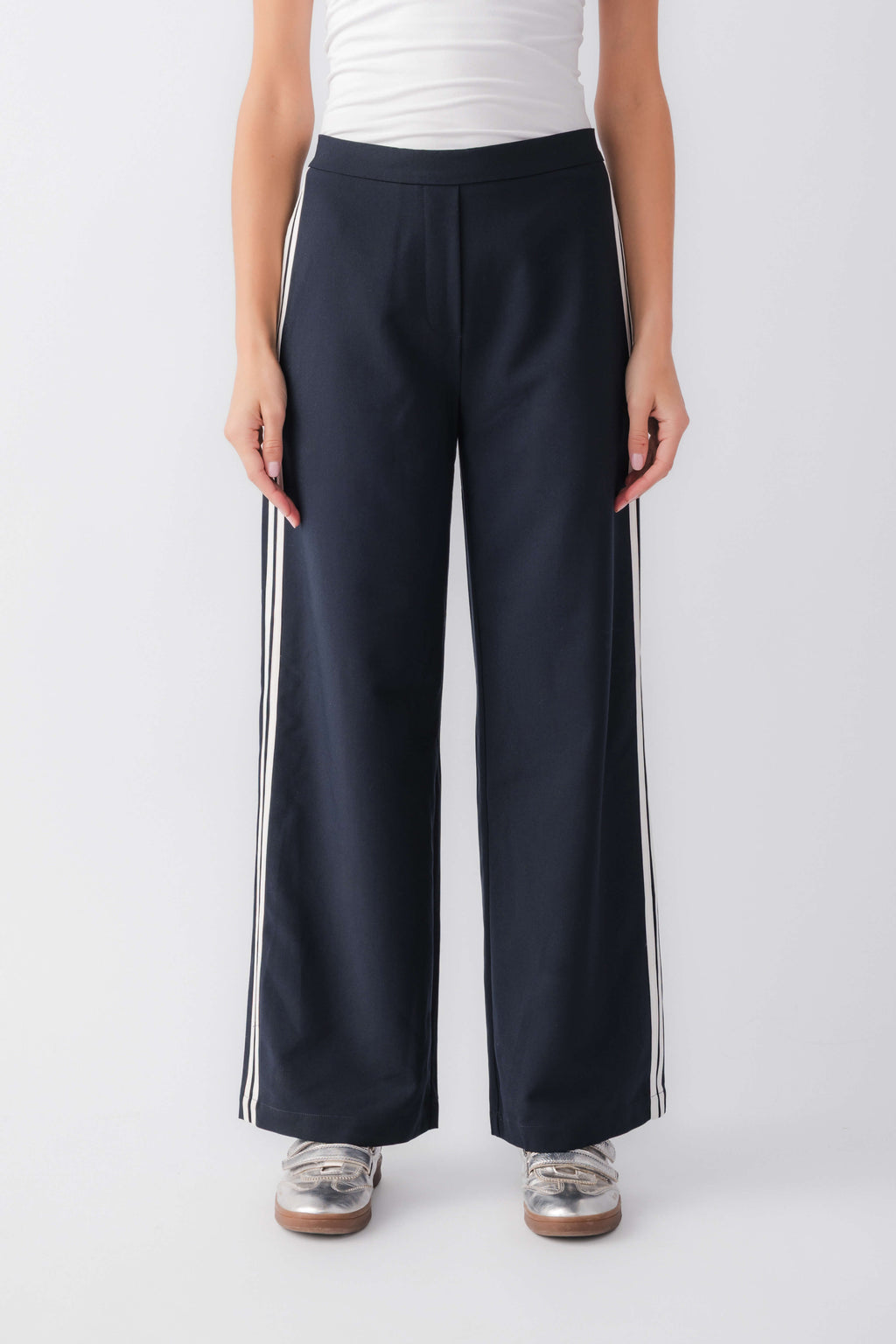 Navy track pants with white stripe detailing and relaxed wide-leg fit