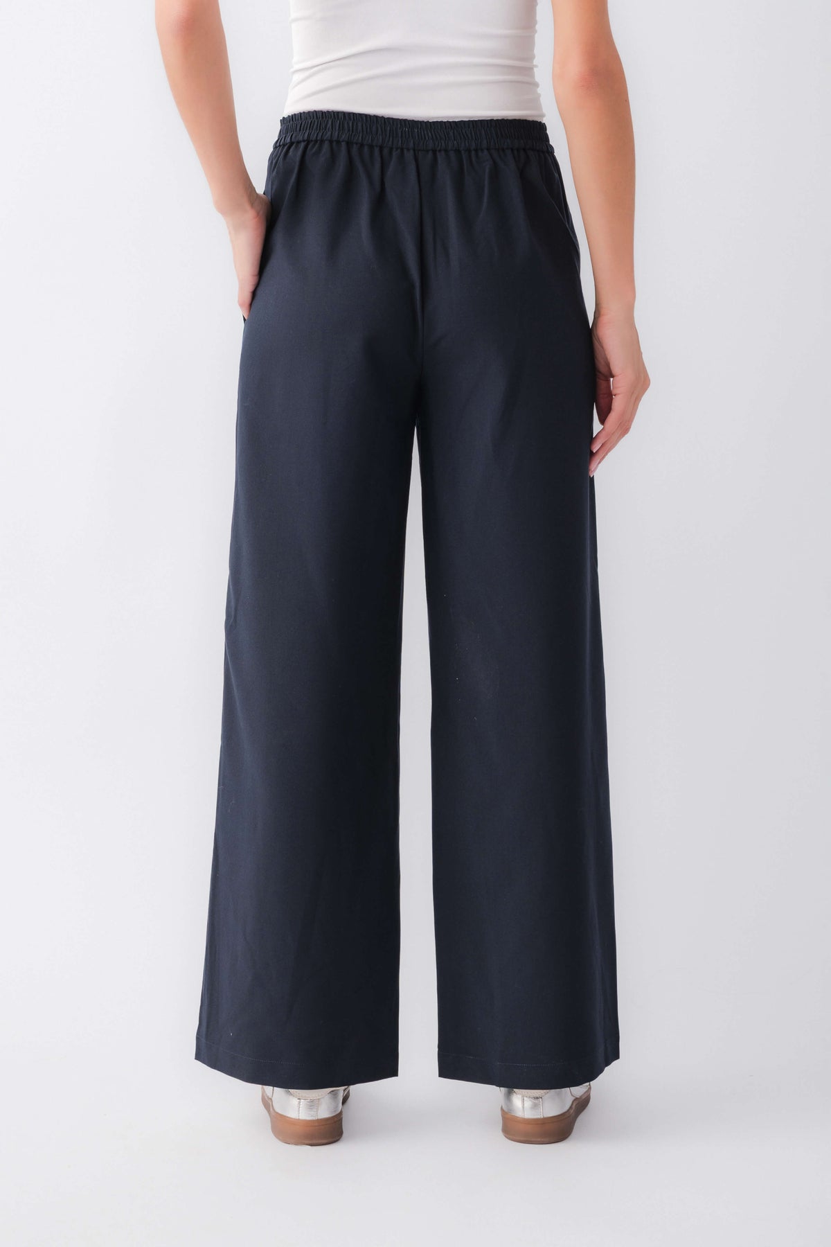 Navy pull-on track pants with elastic waist and white side stripes, wide legs