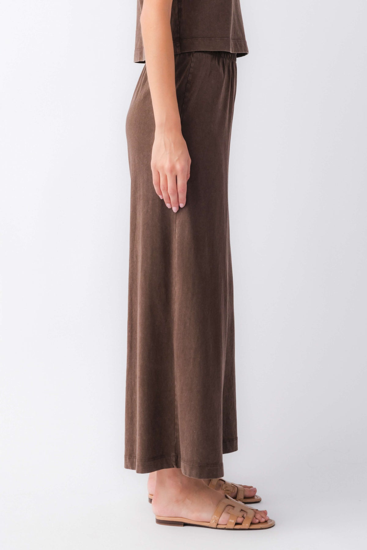Dark brown jersey crop flare pants with elastic waist, side view