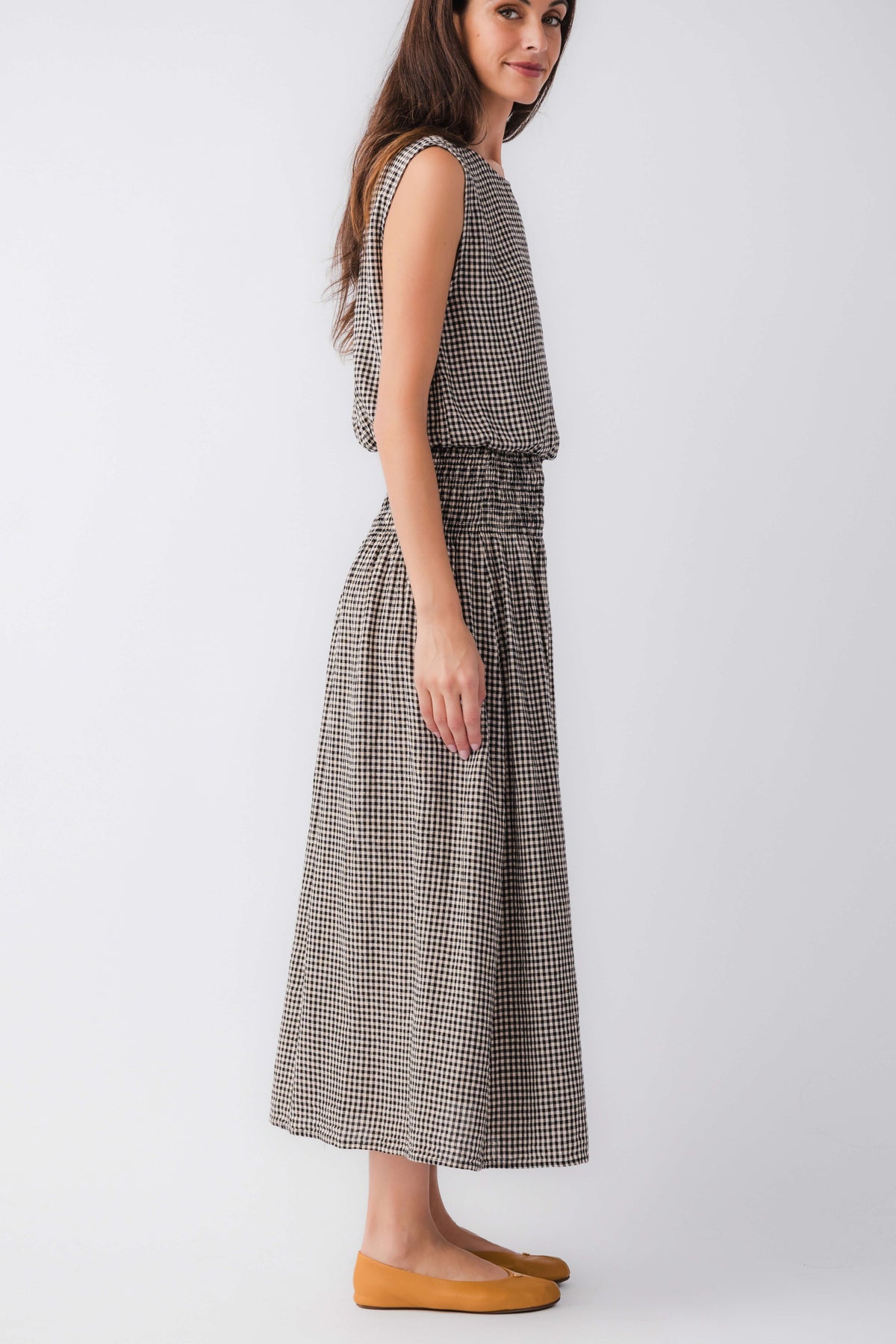 Black-and-white gingham midi skirt with elastic waistband and gathered panels, side view