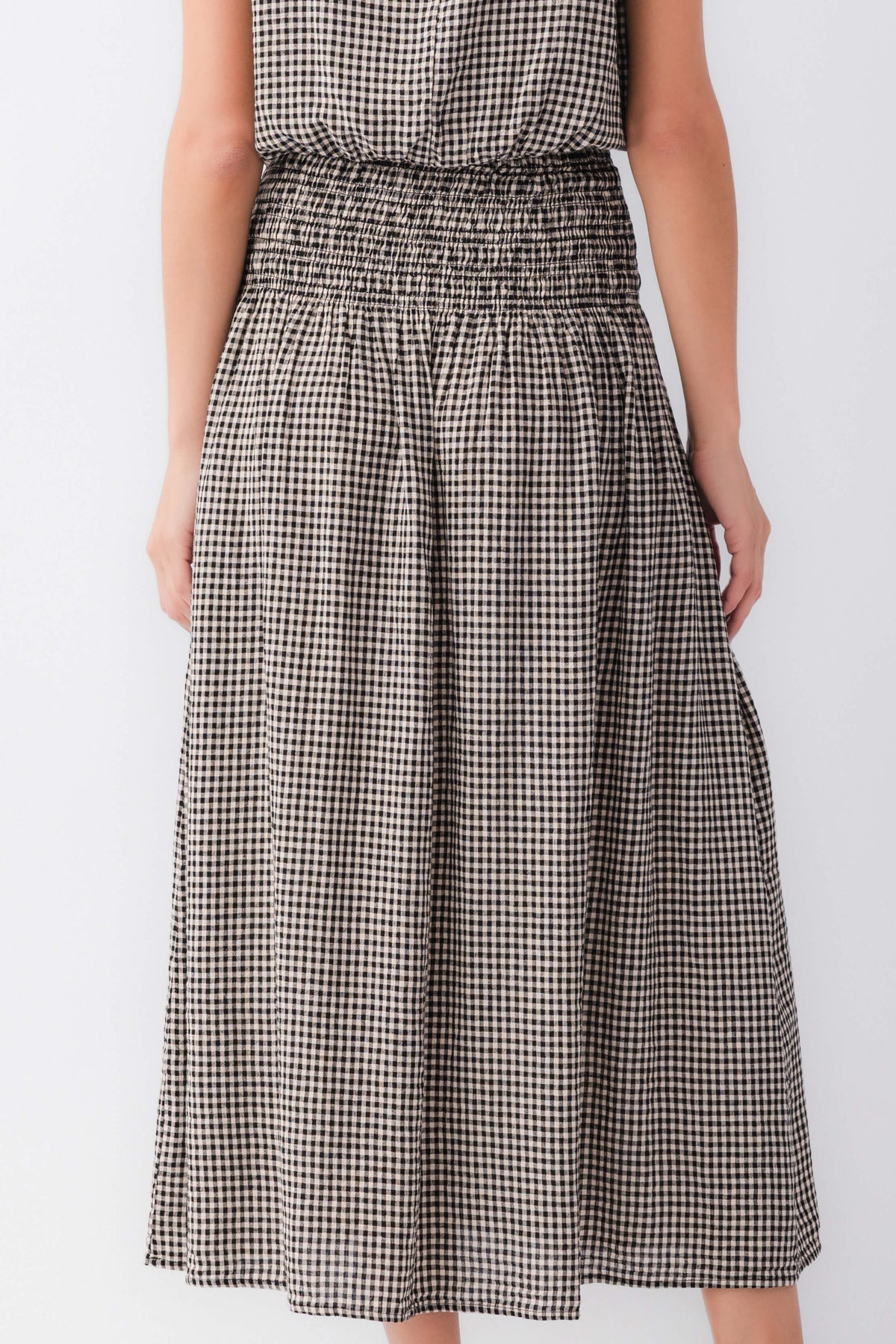 Black-and-white gingham midi skirt close-up: elastic waistband with gathered pleats