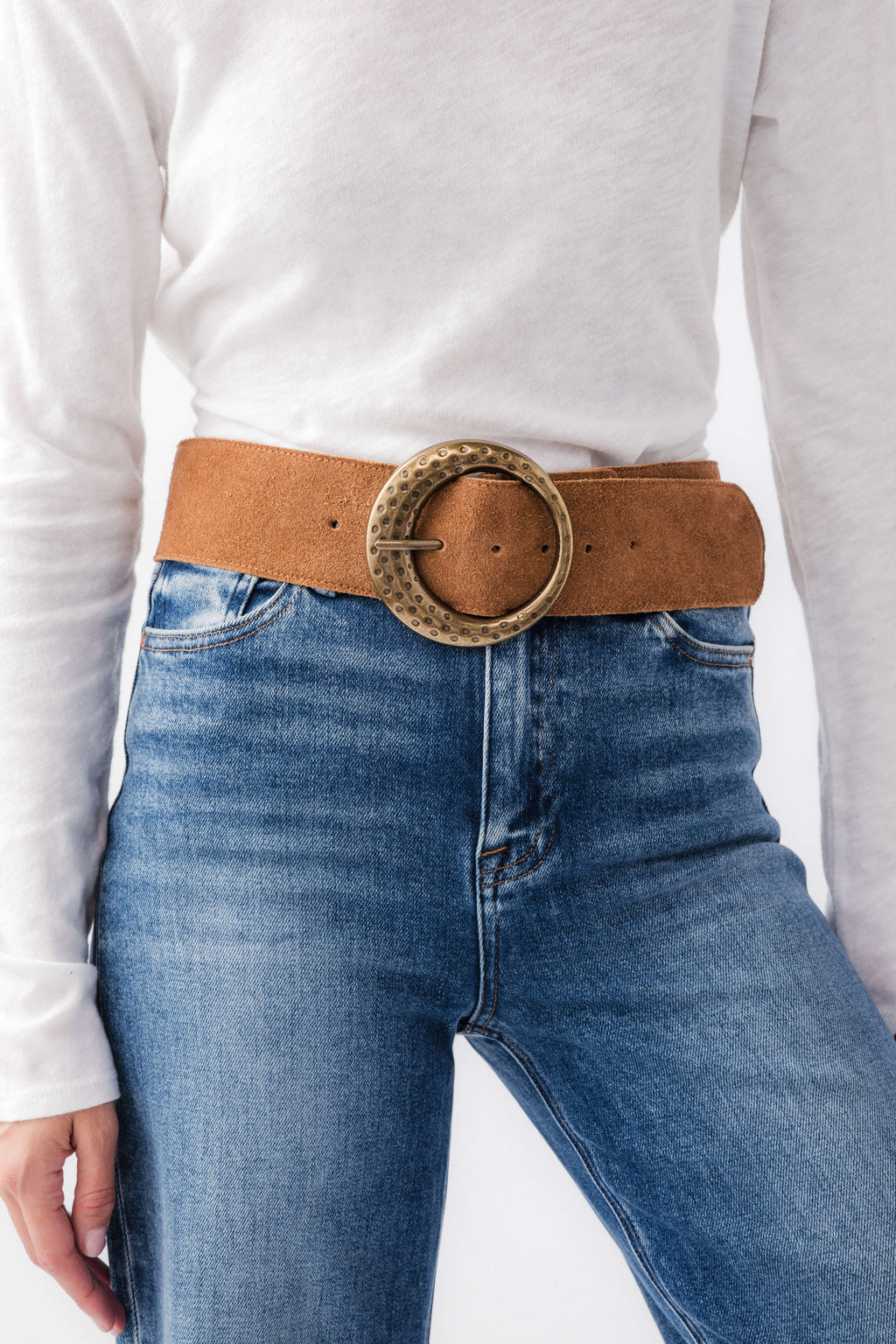 Cognac leather hip belt with round studded buckle across denim waistband