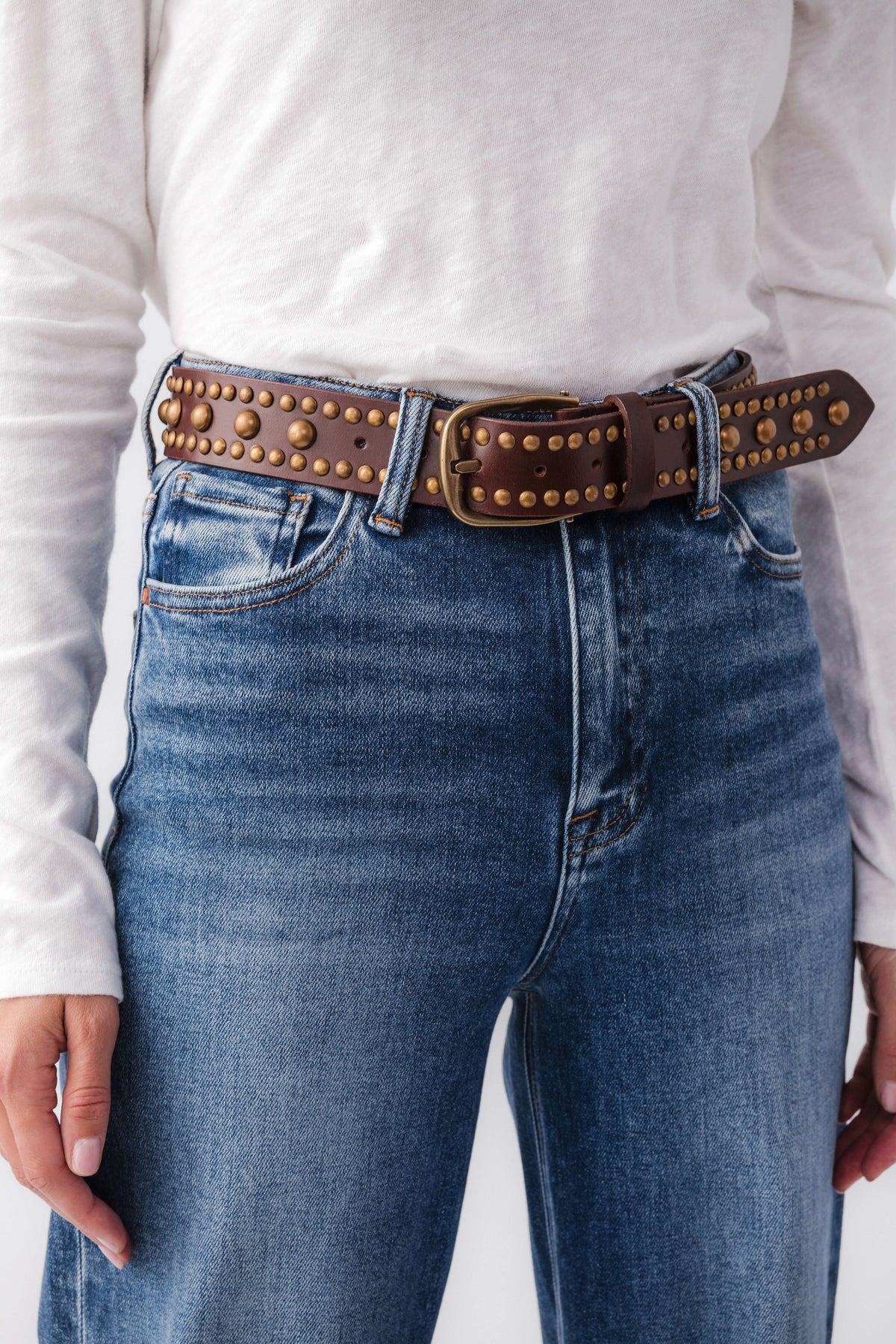 Free People WTF Sola stud belt on jeans, dark brown leather with gold stud trim and buckle.