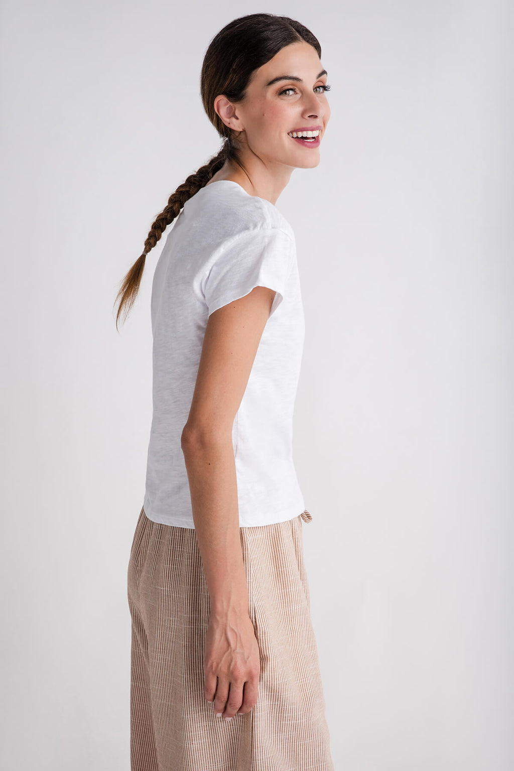 White modern slub tee with short sleeves and crew neck, side view worn with beige pants