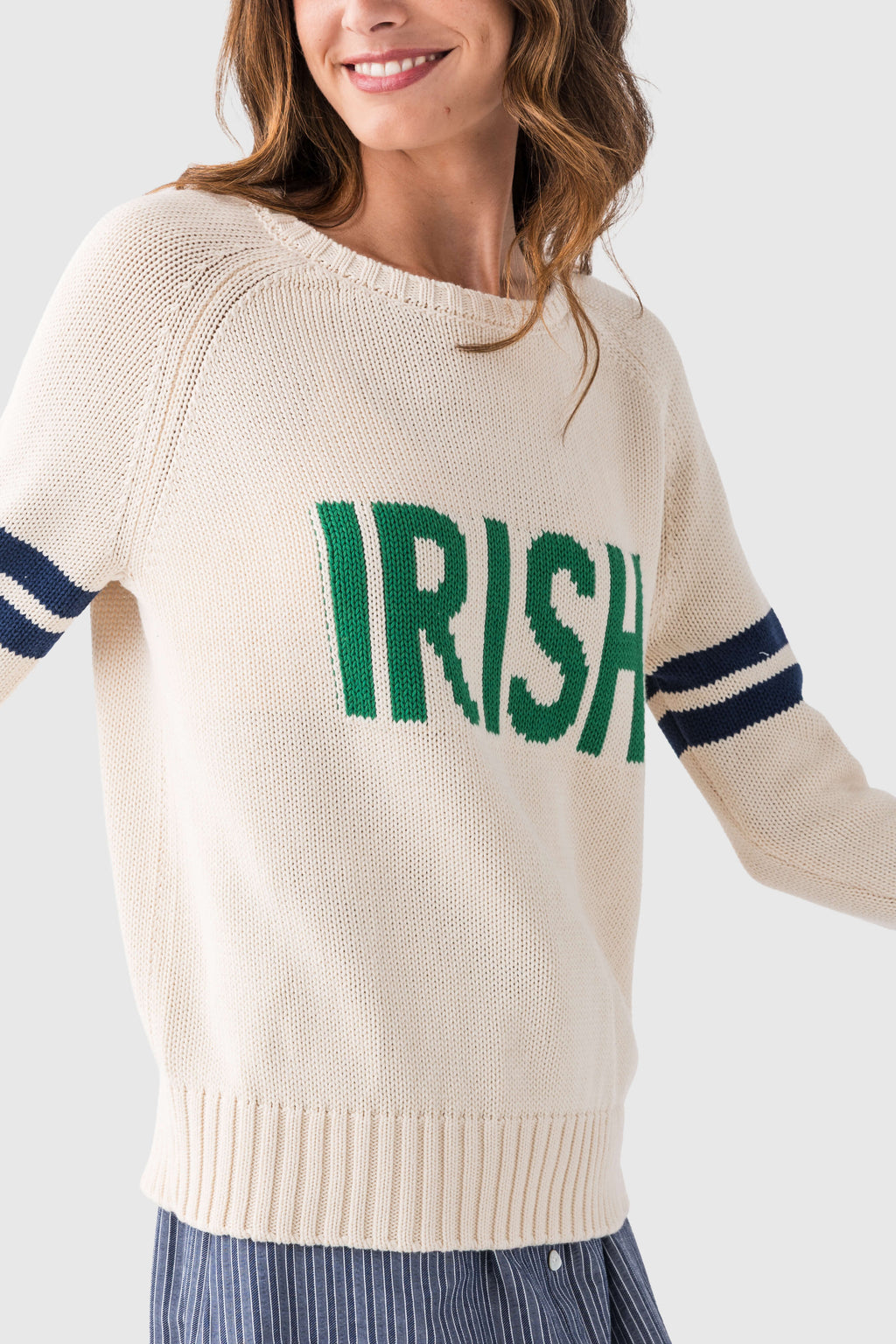 Cream knit sweater with green "IRISH" logo and navy striped sleeve cuff