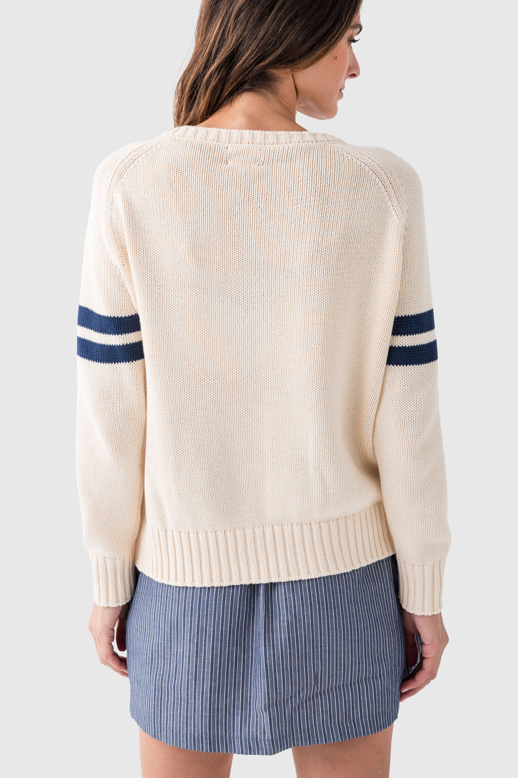 Cream knit sweater back view with ribbed crew neckline and navy-striped sleeves