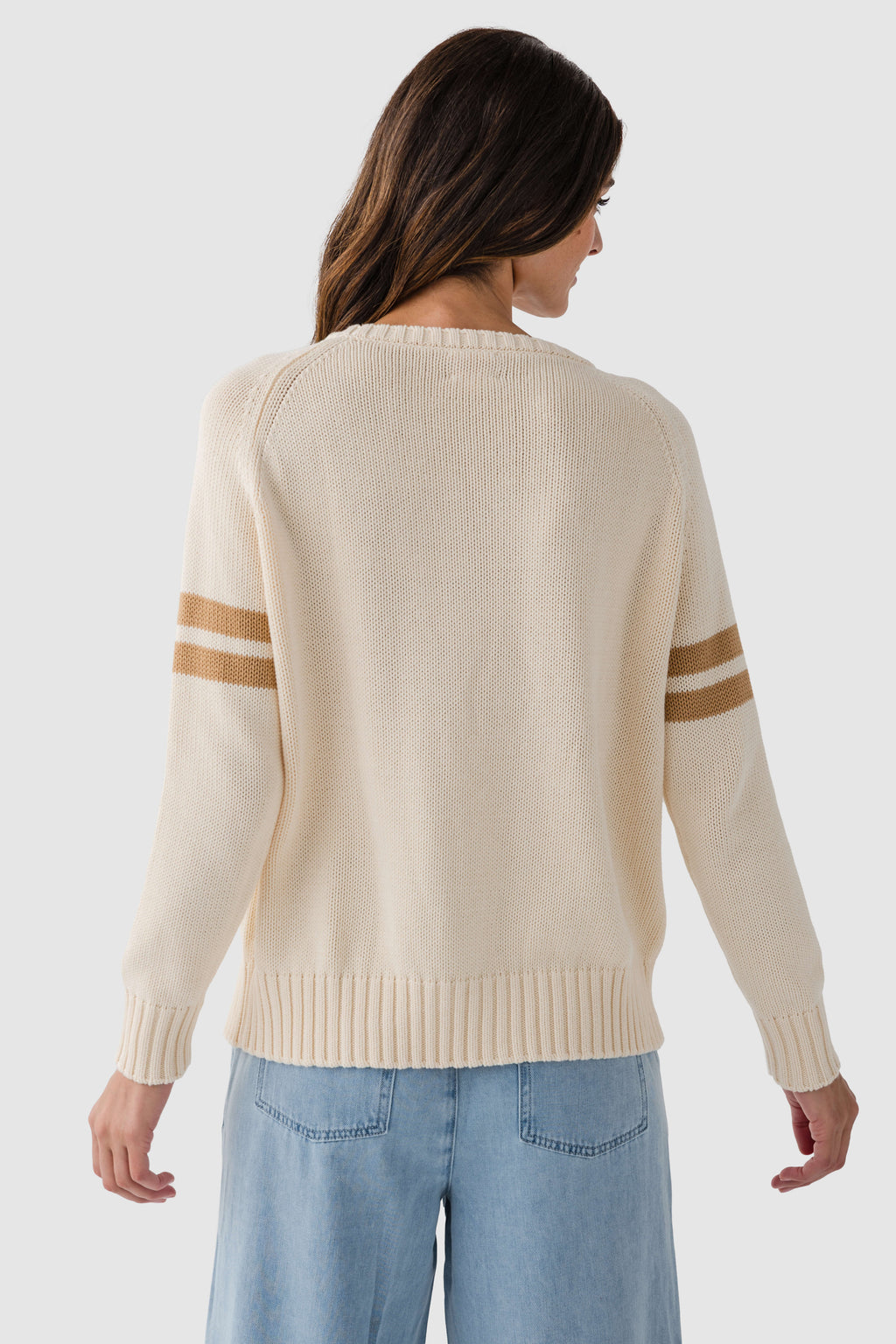 Cream knit sweater back view with navy-striped sleeves and ribbed hem