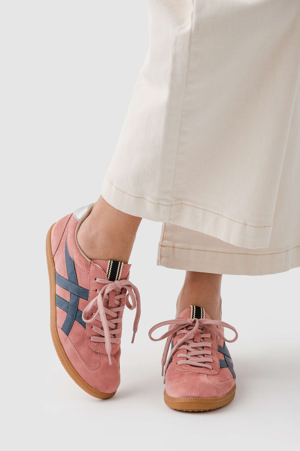 Rose suede sneaker with lace-up front, patterned side stripes, and gum outsole