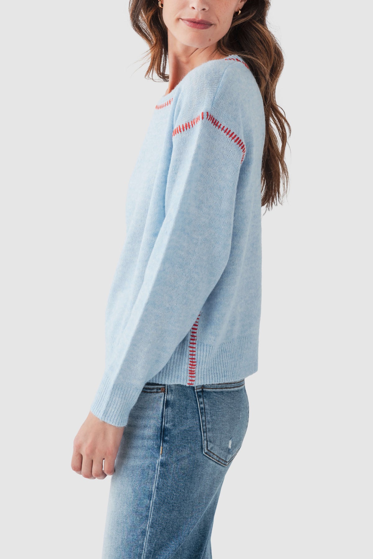 Light blue crewneck sweater, red contrast stitch along shoulder and sleeve seams