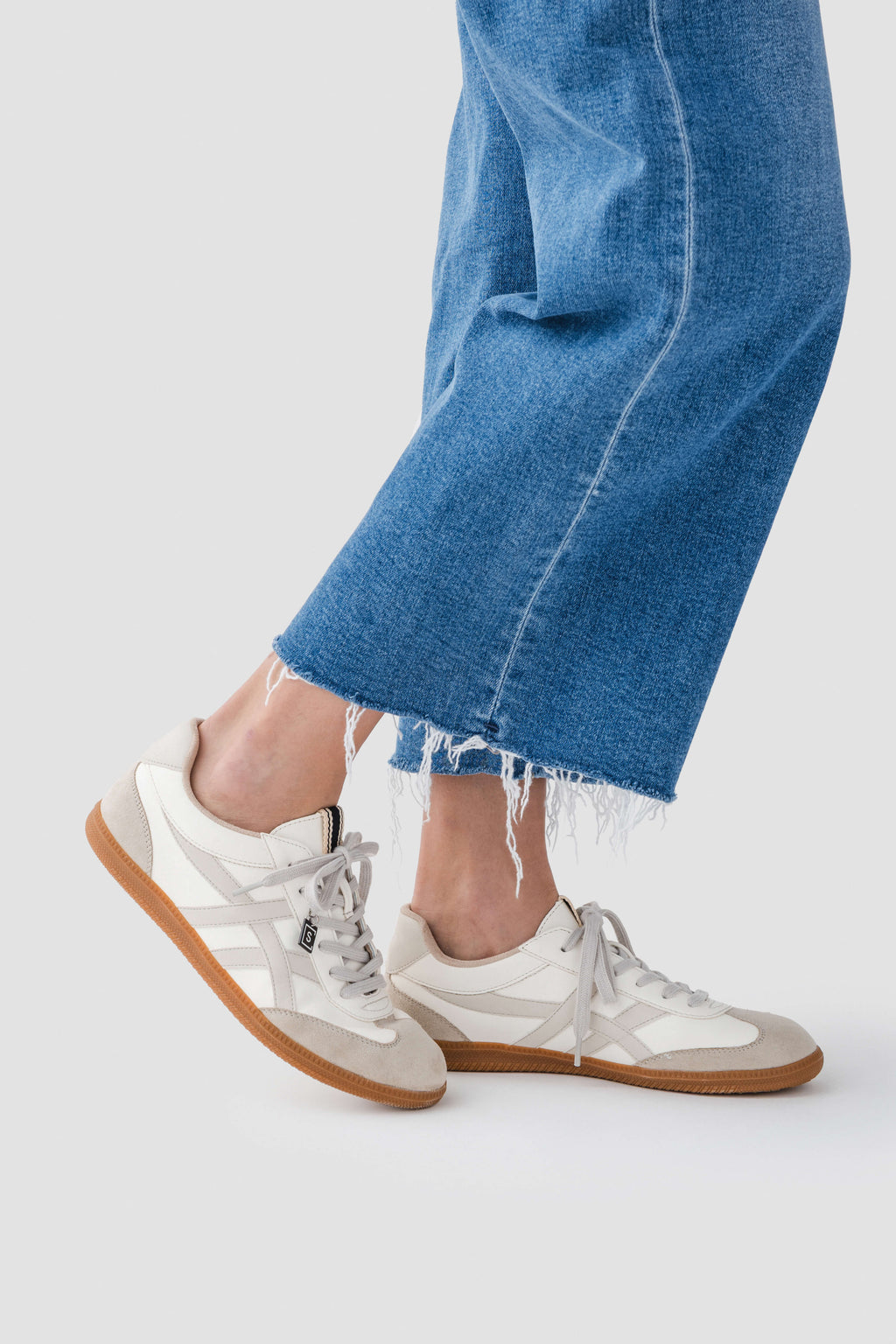 White lace-up sneaker with tan-trim sole and low-profile gum outsole