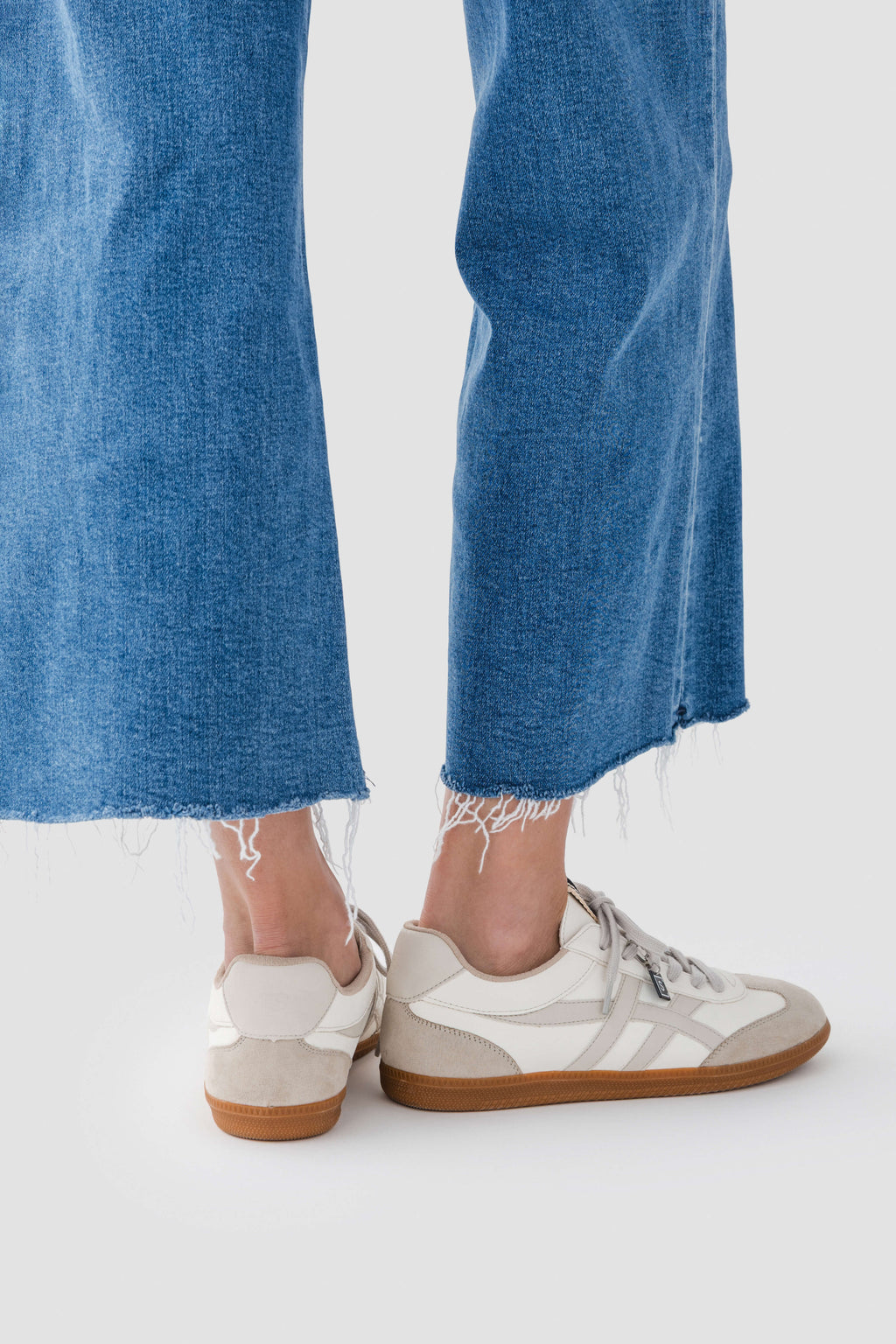 White Sasha low-top sneakers with lace-up front, striped sides, and gum sole