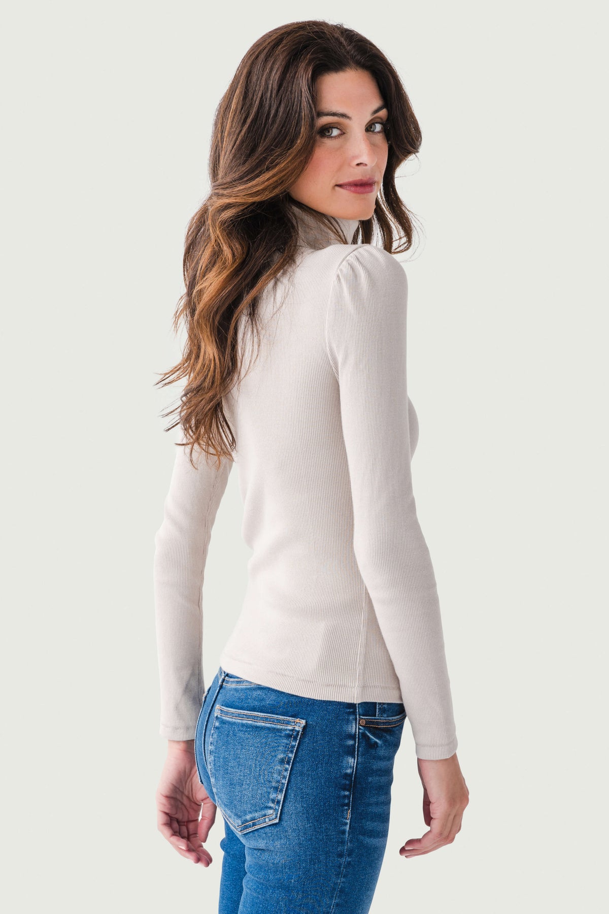 Light cream fitted long-sleeve turtleneck top, side profile
