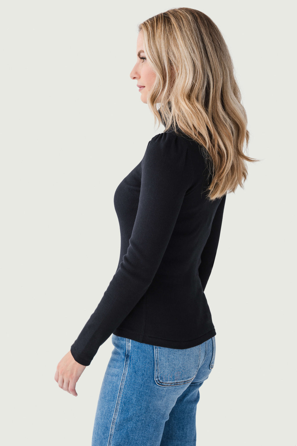 Black fitted long-sleeve turtleneck top, side view