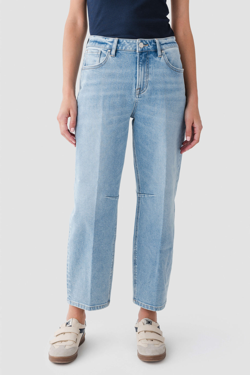 Medium wash barrel jeans in relaxed wide-leg style with belt loops and stitched pockets.