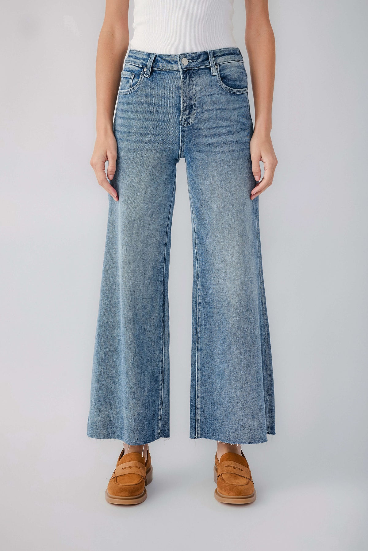 Medium blue wide-leg denim jeans with raw hem and visible belt loops