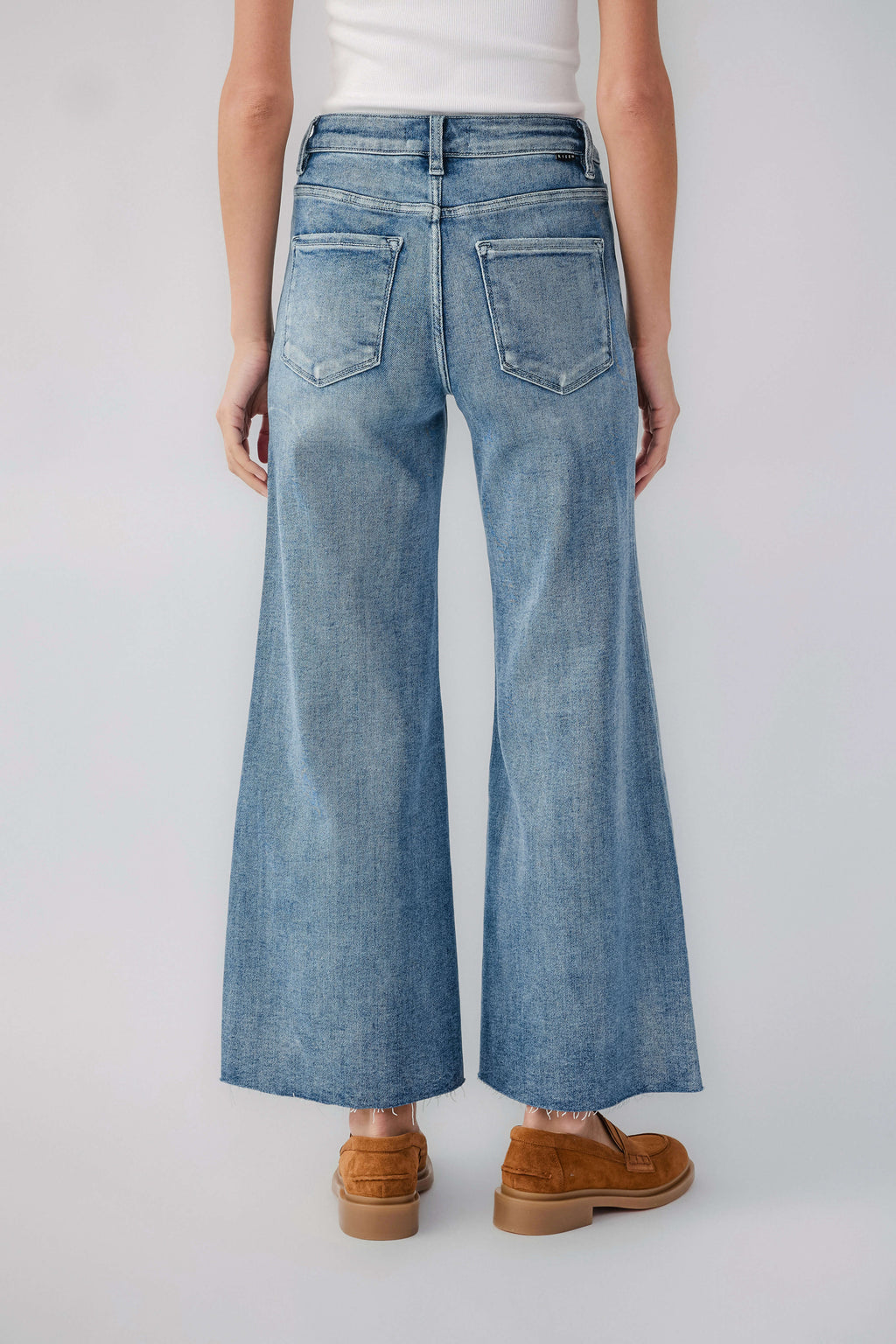 Light wash wide-leg denim jeans with raw hem and back patch pockets