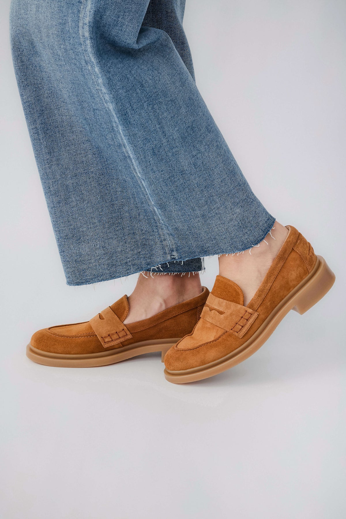 Tan suede slip-on loafer with moc-style strap detail and low rubber sole