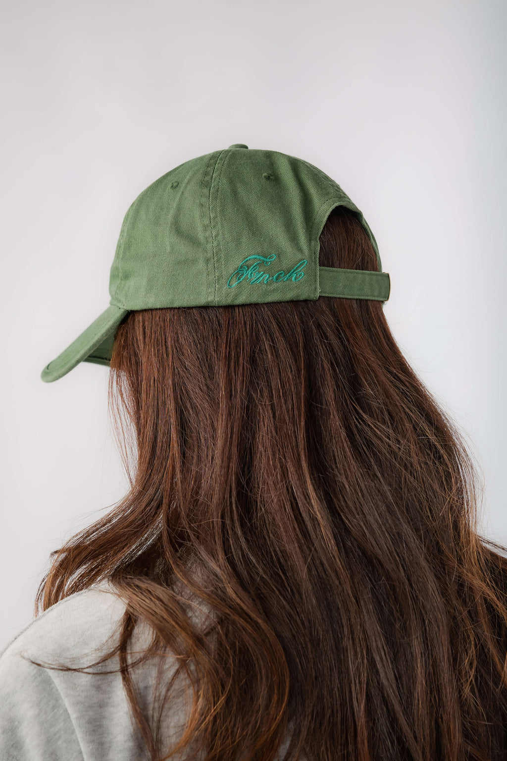 Green baseball cap with blue embroidered back lettering