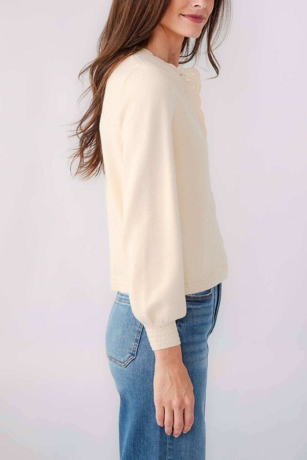 Cream cardigan with button placket and long sleeves, side view