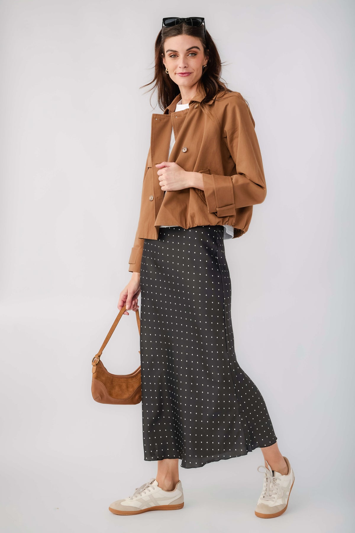 Black satin midi skirt with small white polka dots, front view