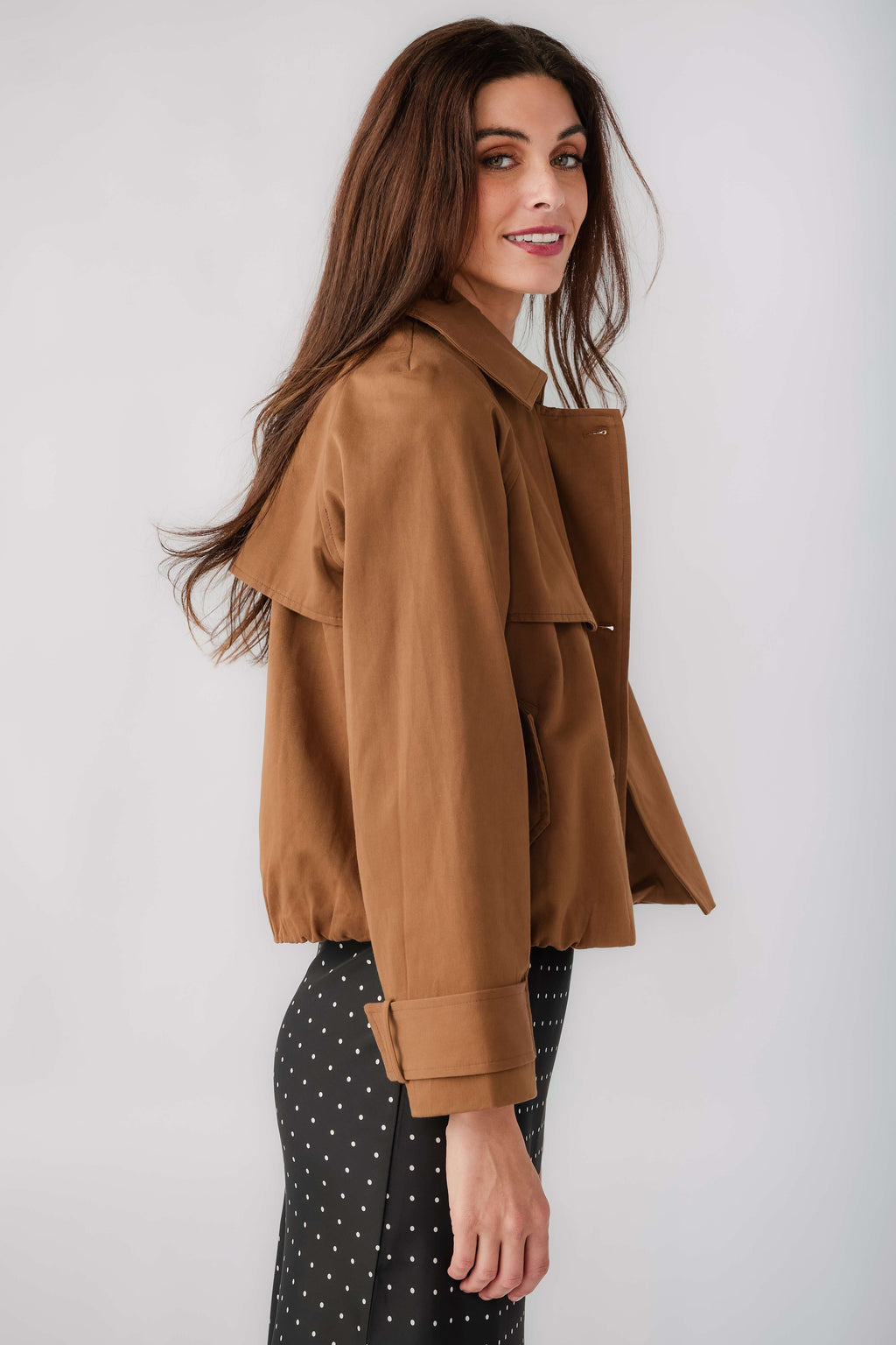Brown cropped trench jacket, side view with point collar and buttoned flap details