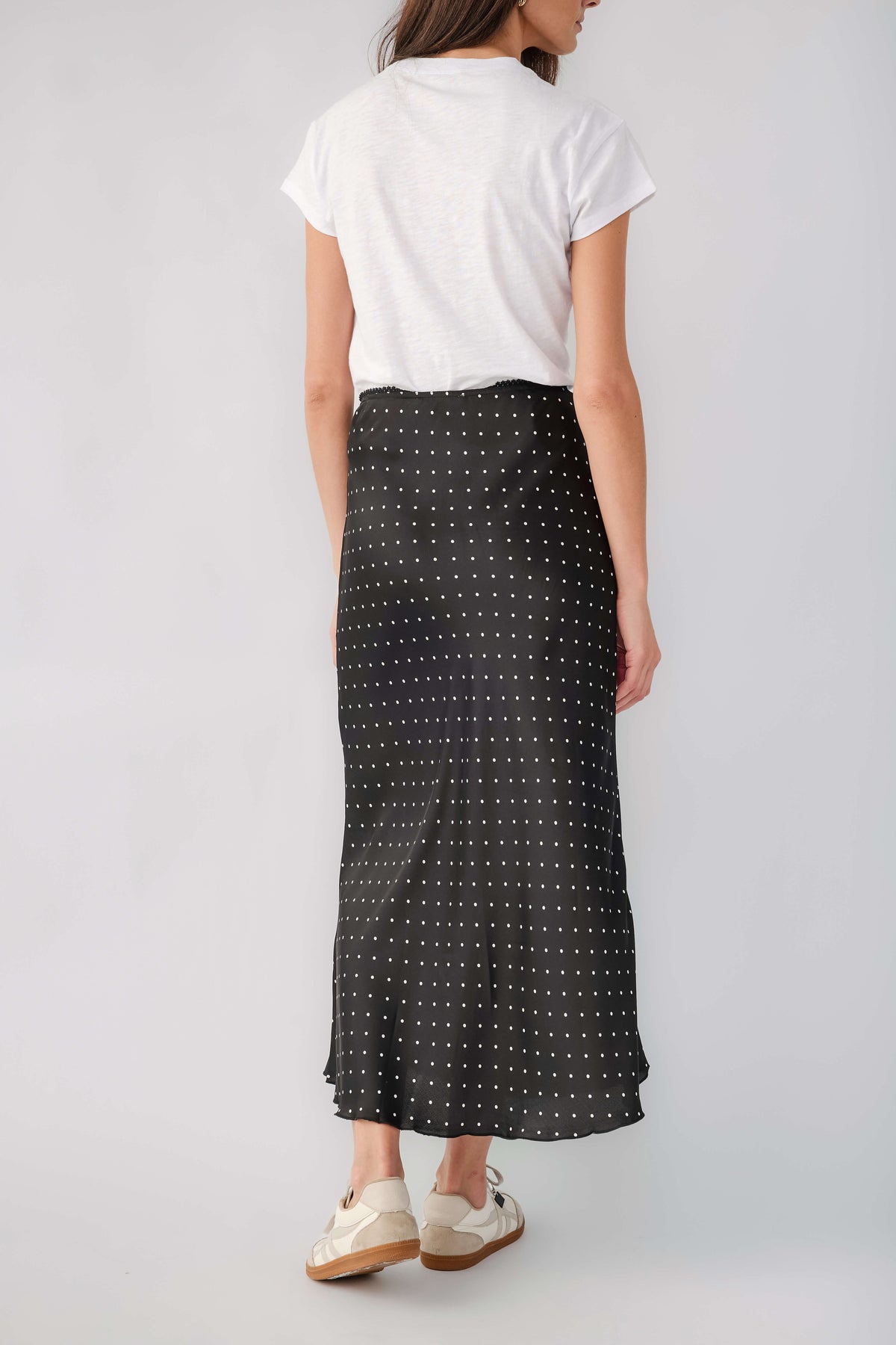 Black satin midi skirt with white polka dots, back view