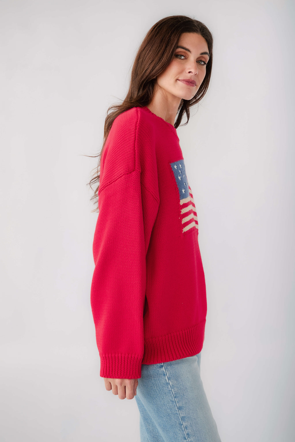 Red crewneck sweater with flag graphic on the sleeve and ribbed cuffs