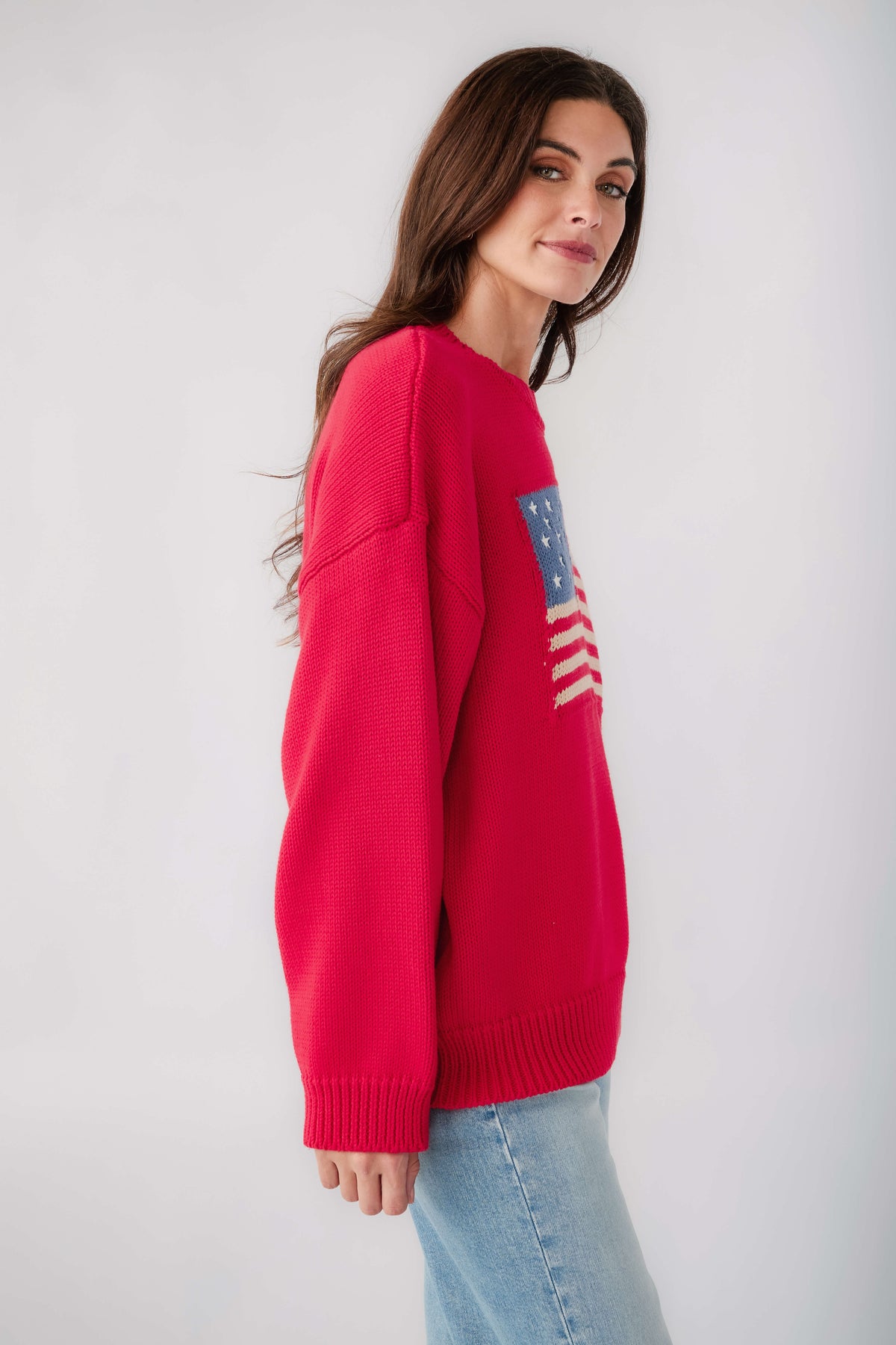 Red crewneck sweater with flag graphic on the sleeve and ribbed cuffs