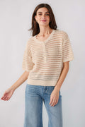 Cream open-knit polo sweater with button front and short sleeves, relaxed fit