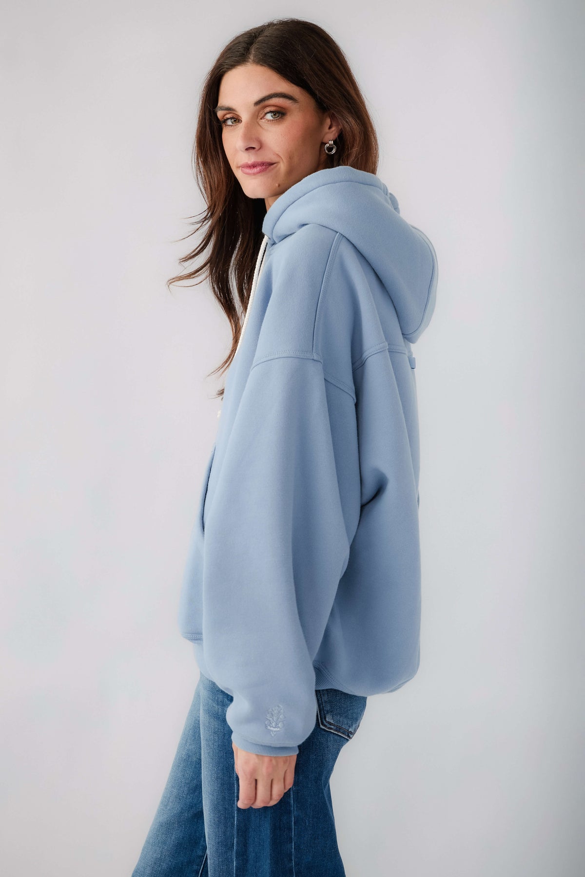Light blue pullover hoodie with drawstring hood and kangaroo pocket, side view