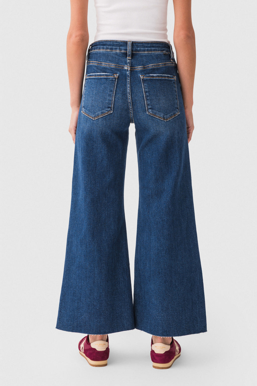 Back view of dark blue raw-hem palazzo jeans with stitched pockets and wide legs