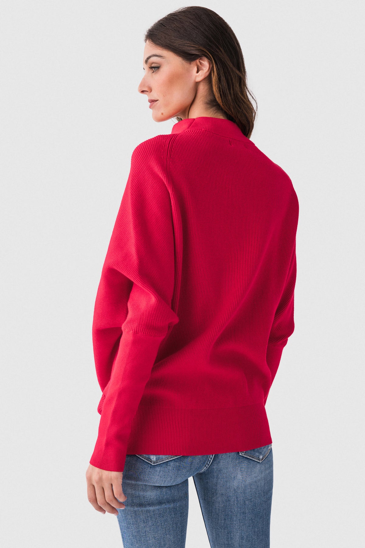 Red dolman pullover sweater with slouch neck and long sleeves, side view.
