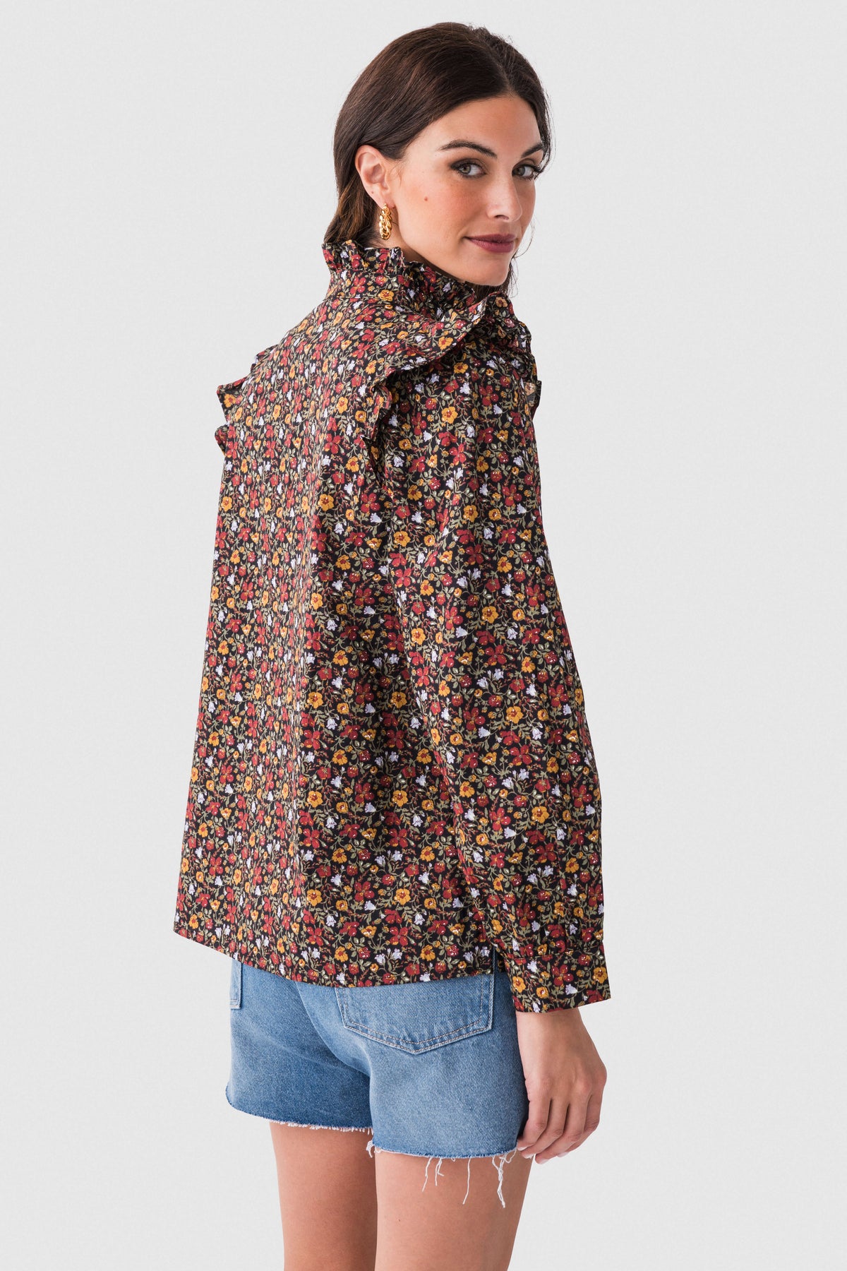 Black floral ruffle detail top shown from the side, high neck and long sleeves