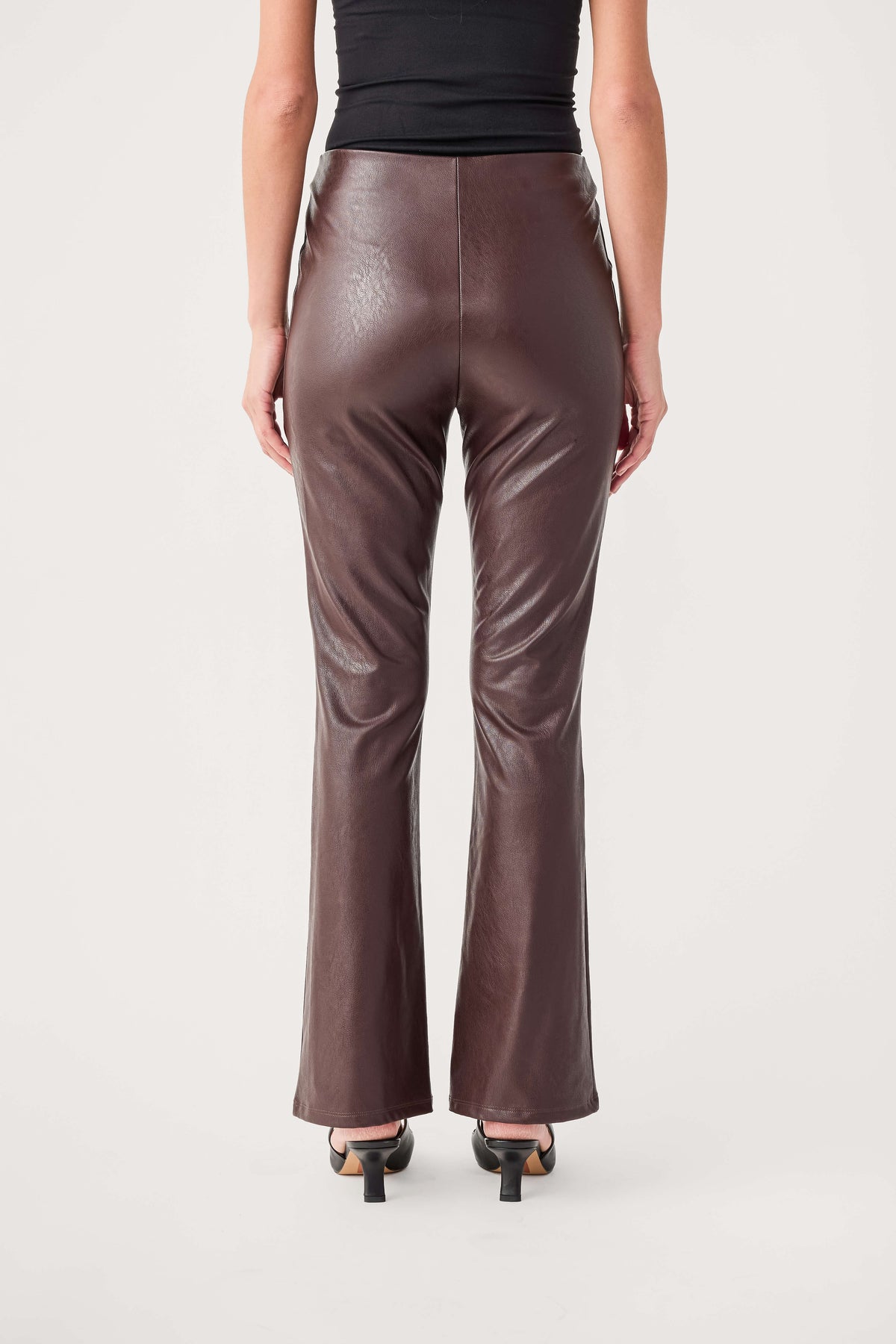 Dark taupe-brown faux leather flare pants, back view with center seam
