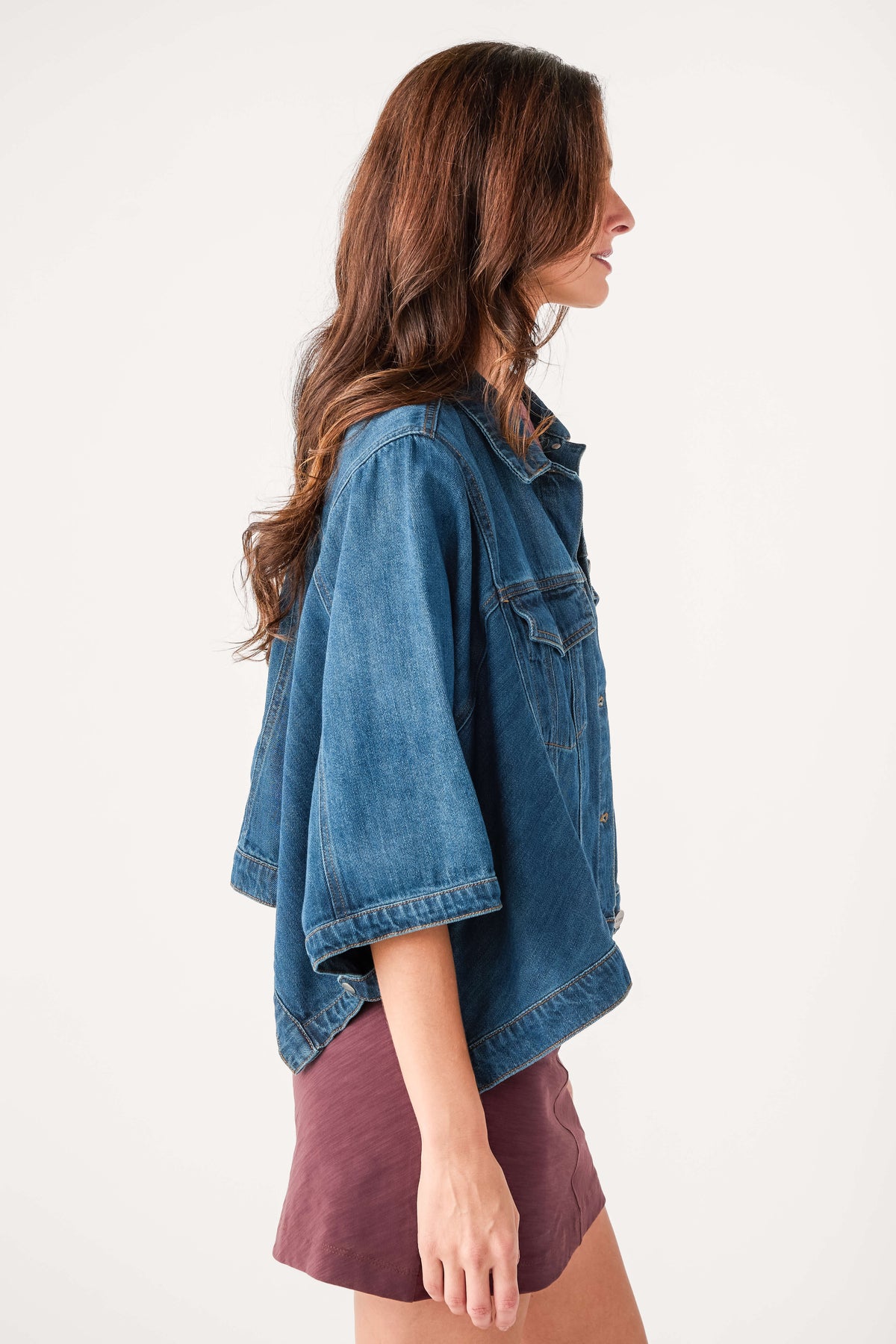 Cape-sleeve denim jacket in medium blue wash with button front, side profile